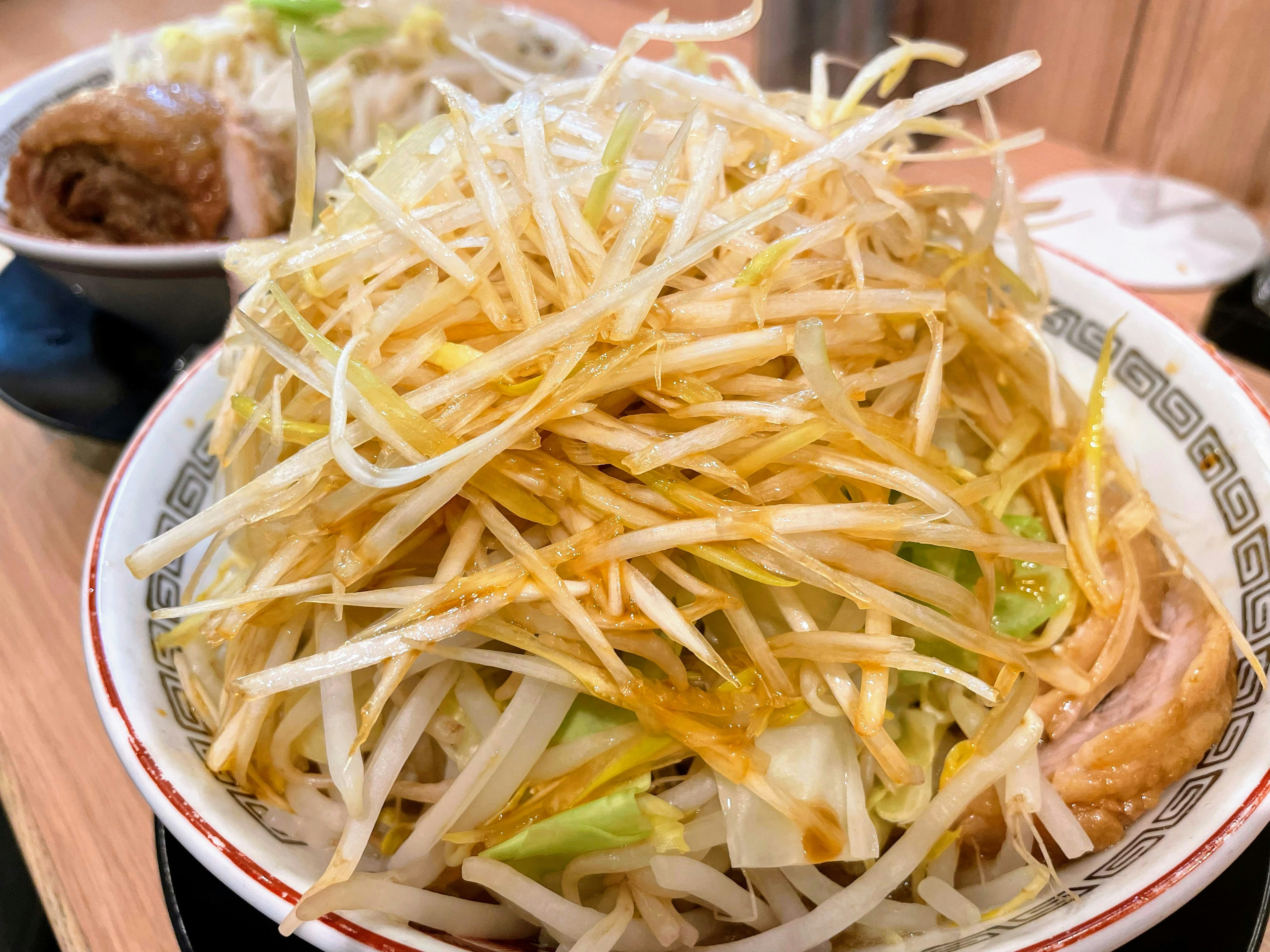 Un tazón de ramen cubierto con una generosa porción de brotes de soja y repollo