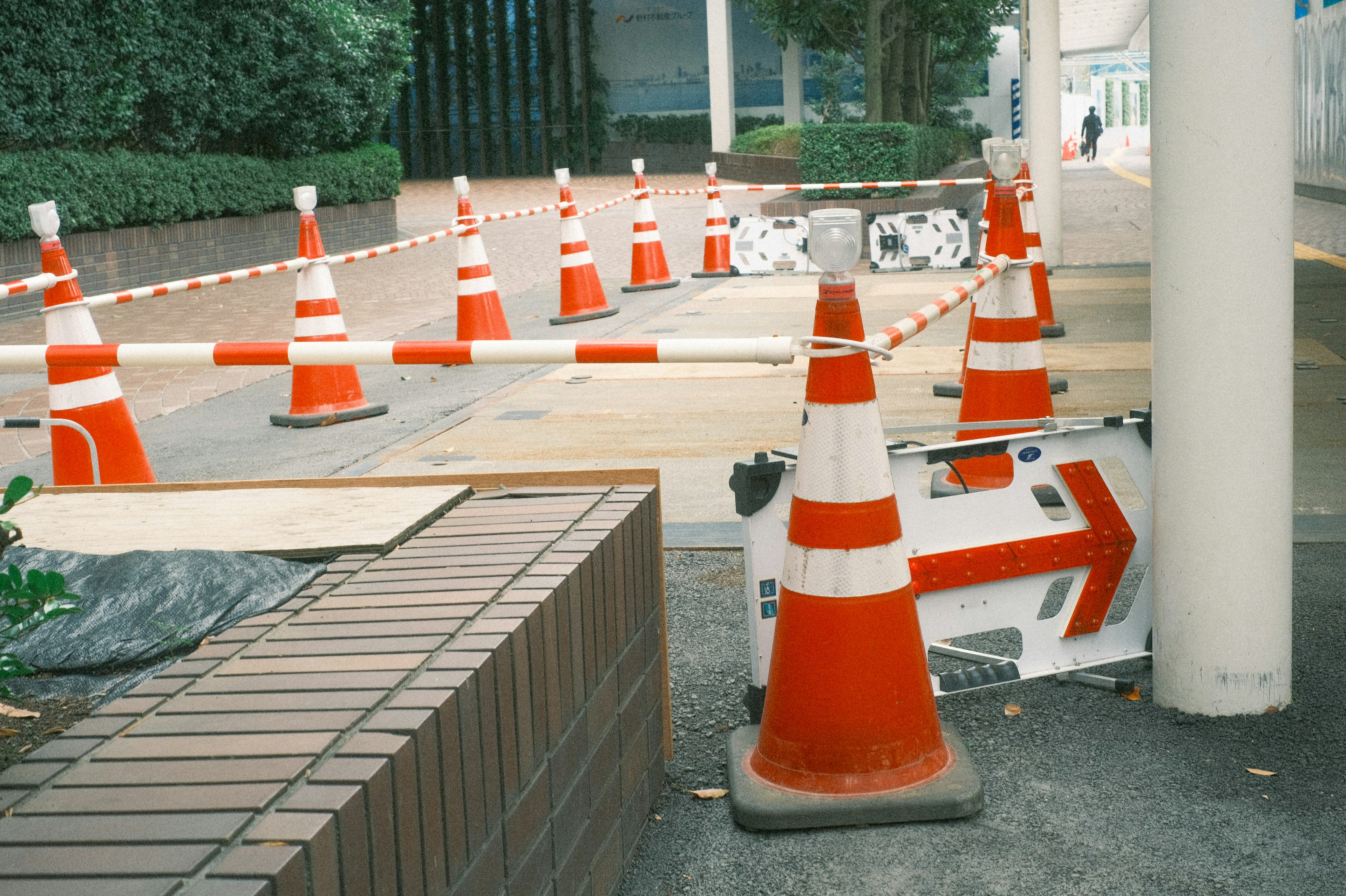 Eine Reihe von orangefarbenen Verkehrsleitkegeln und ein Pfeilschild, das eine Umleitung anzeigt