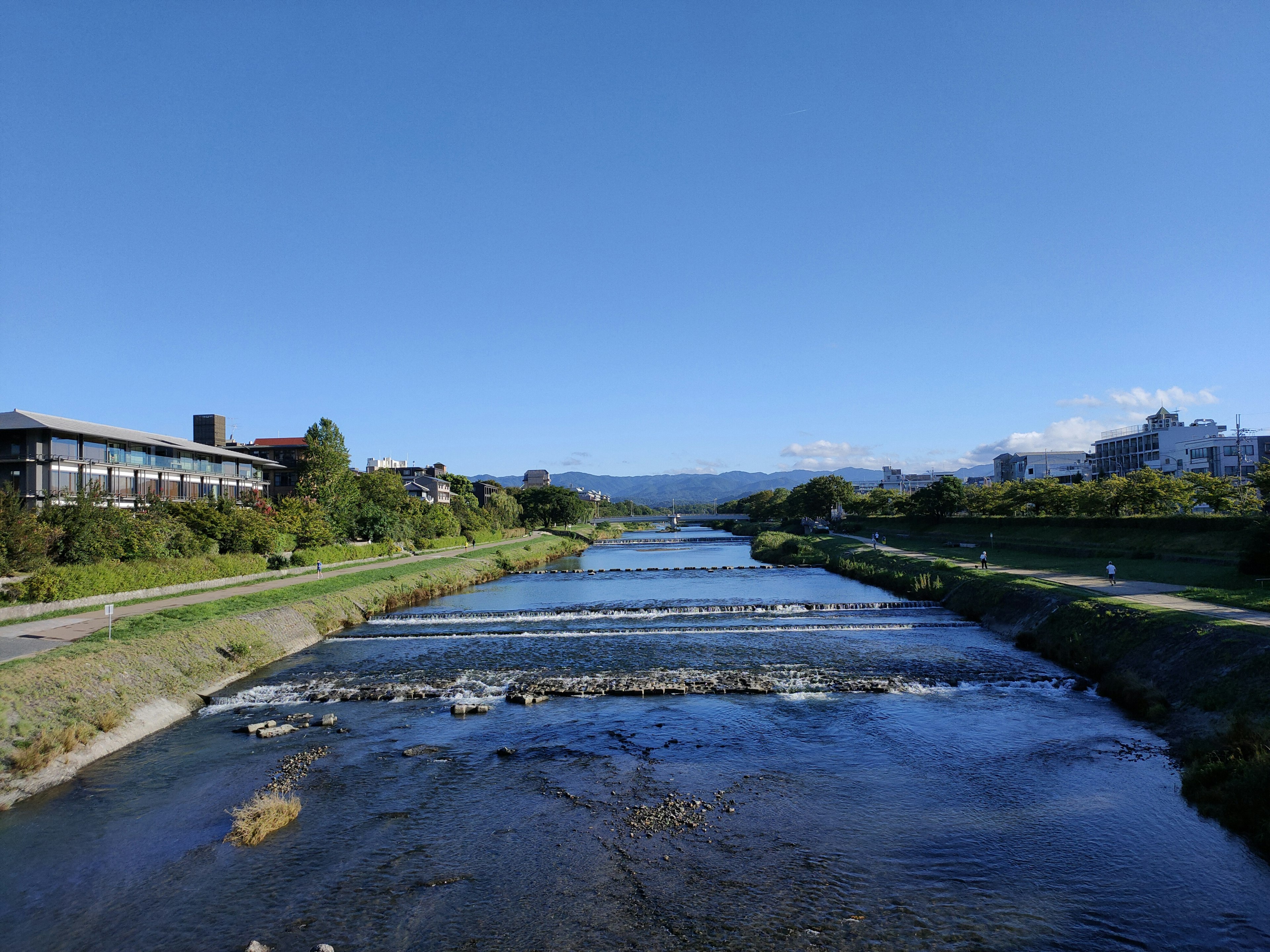 Vue pittoresque d'une rivière bordée de verdure et d'un ciel bleu clair