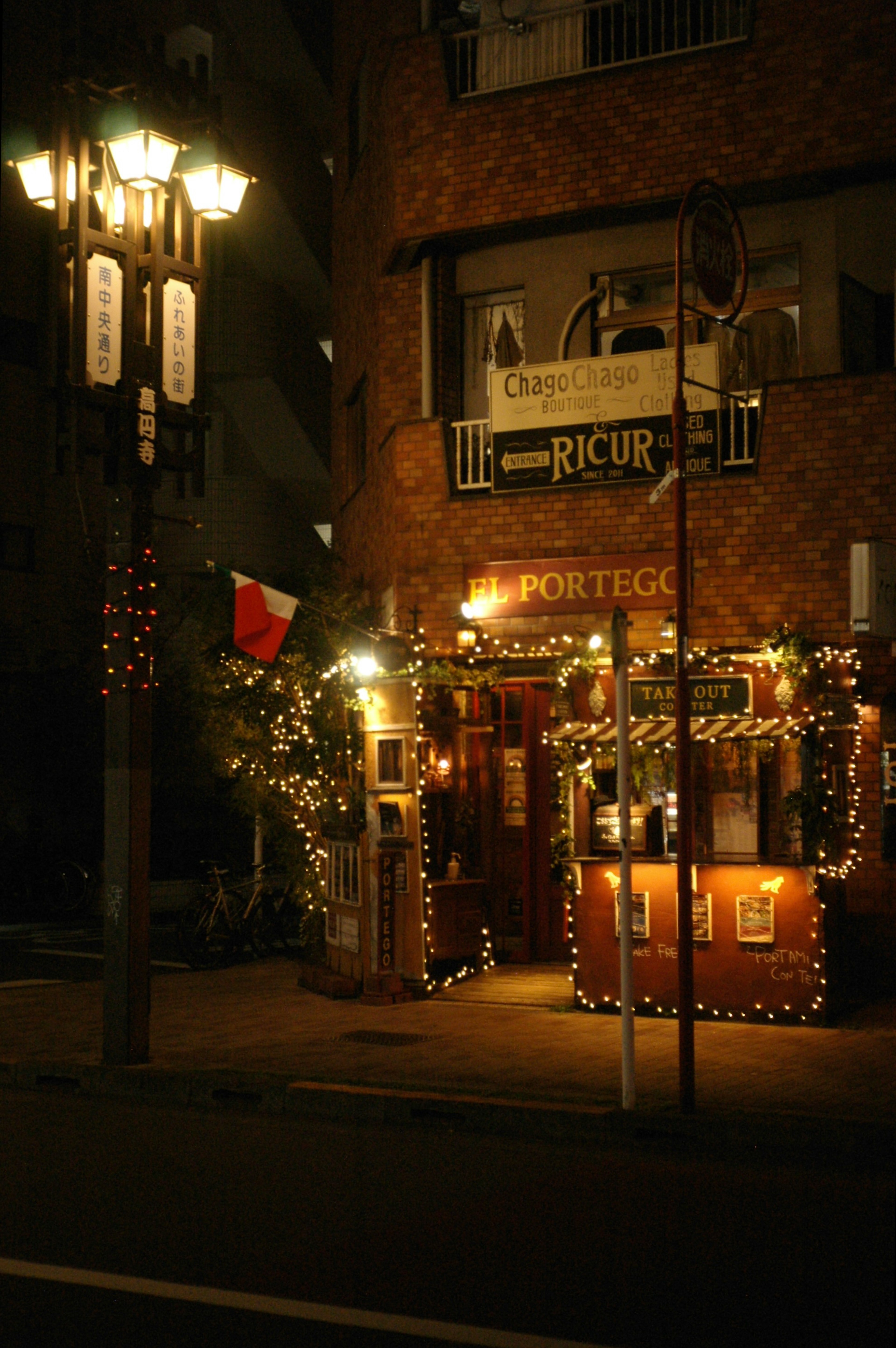 Exterior de restaurante decorado por la noche en una esquina de la calle