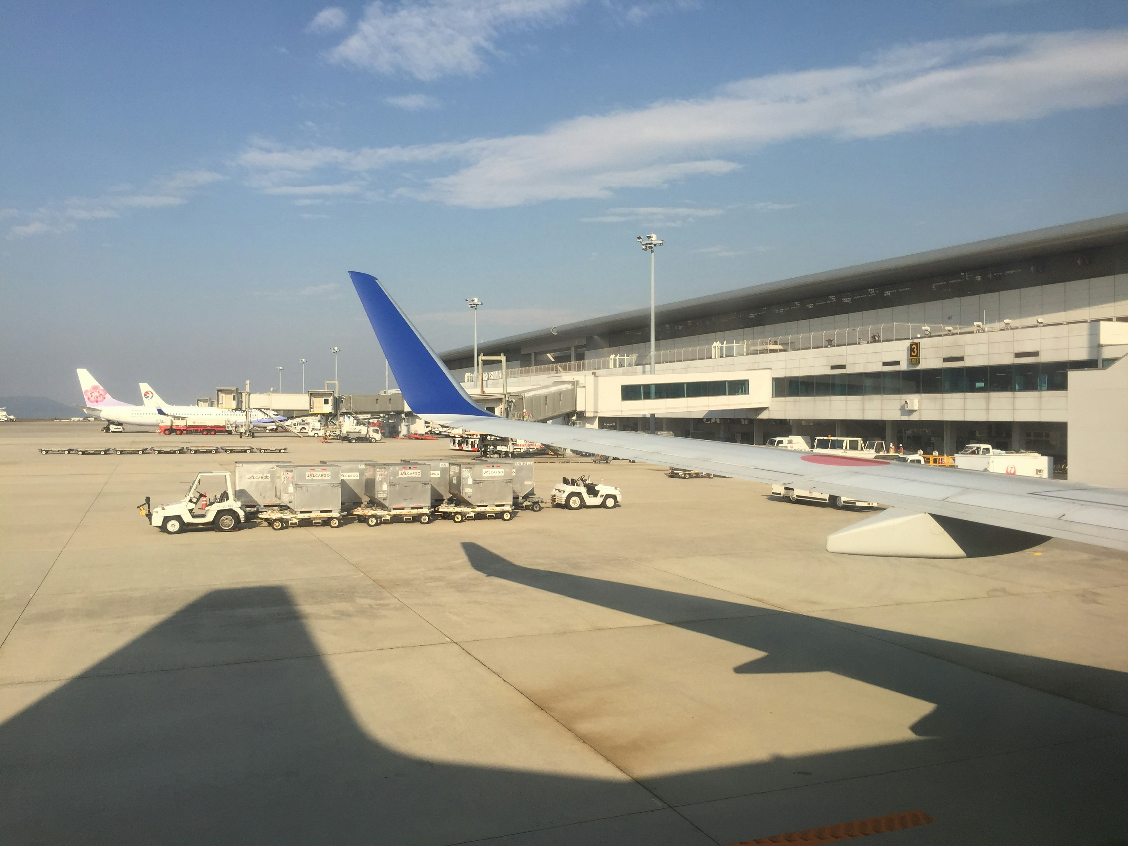 Vue d'une piste d'aéroport et d'un terminal avec des avions et des véhicules de service au sol