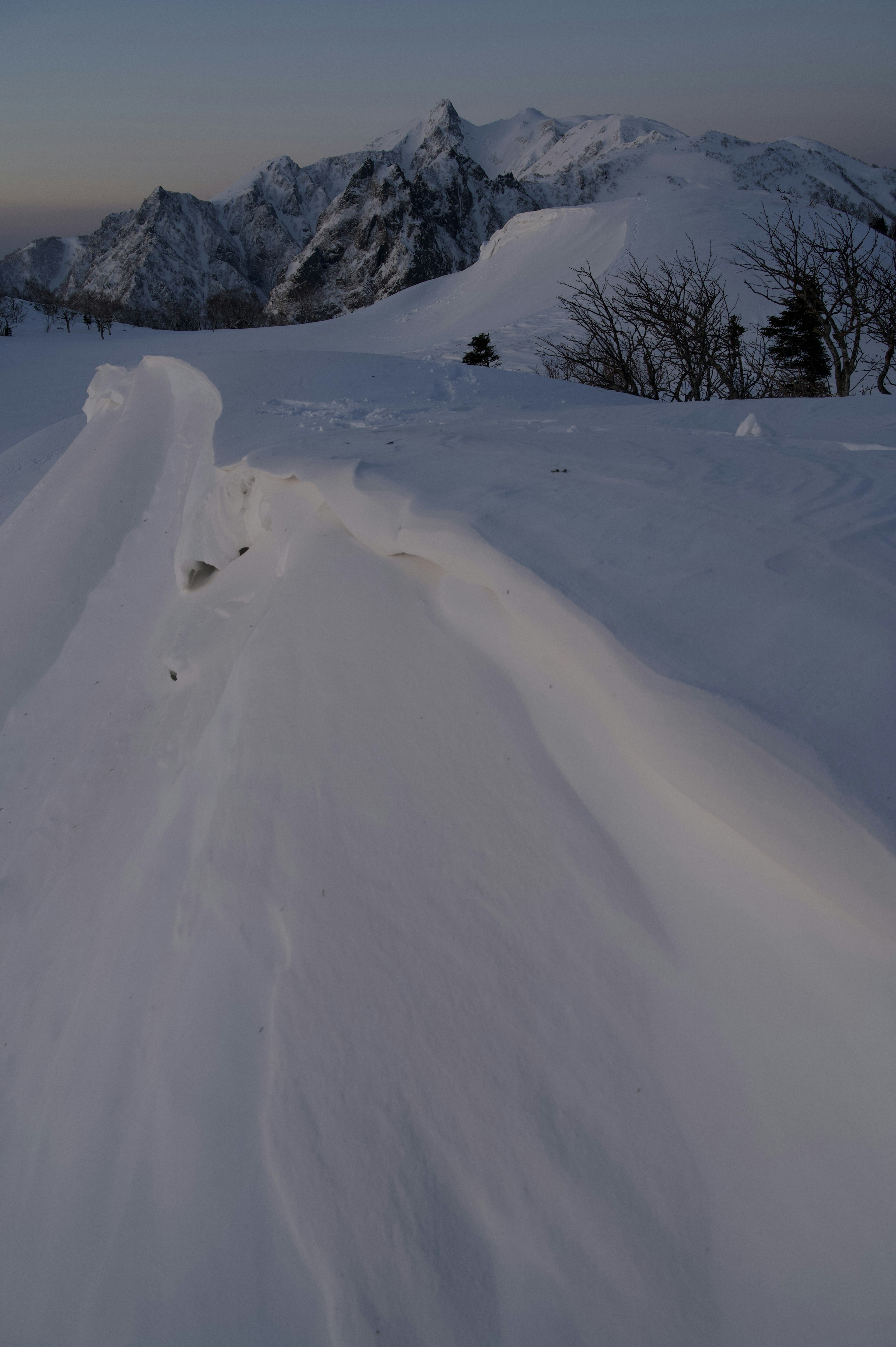 Snow-covered mountain landscape with smooth snow drifts