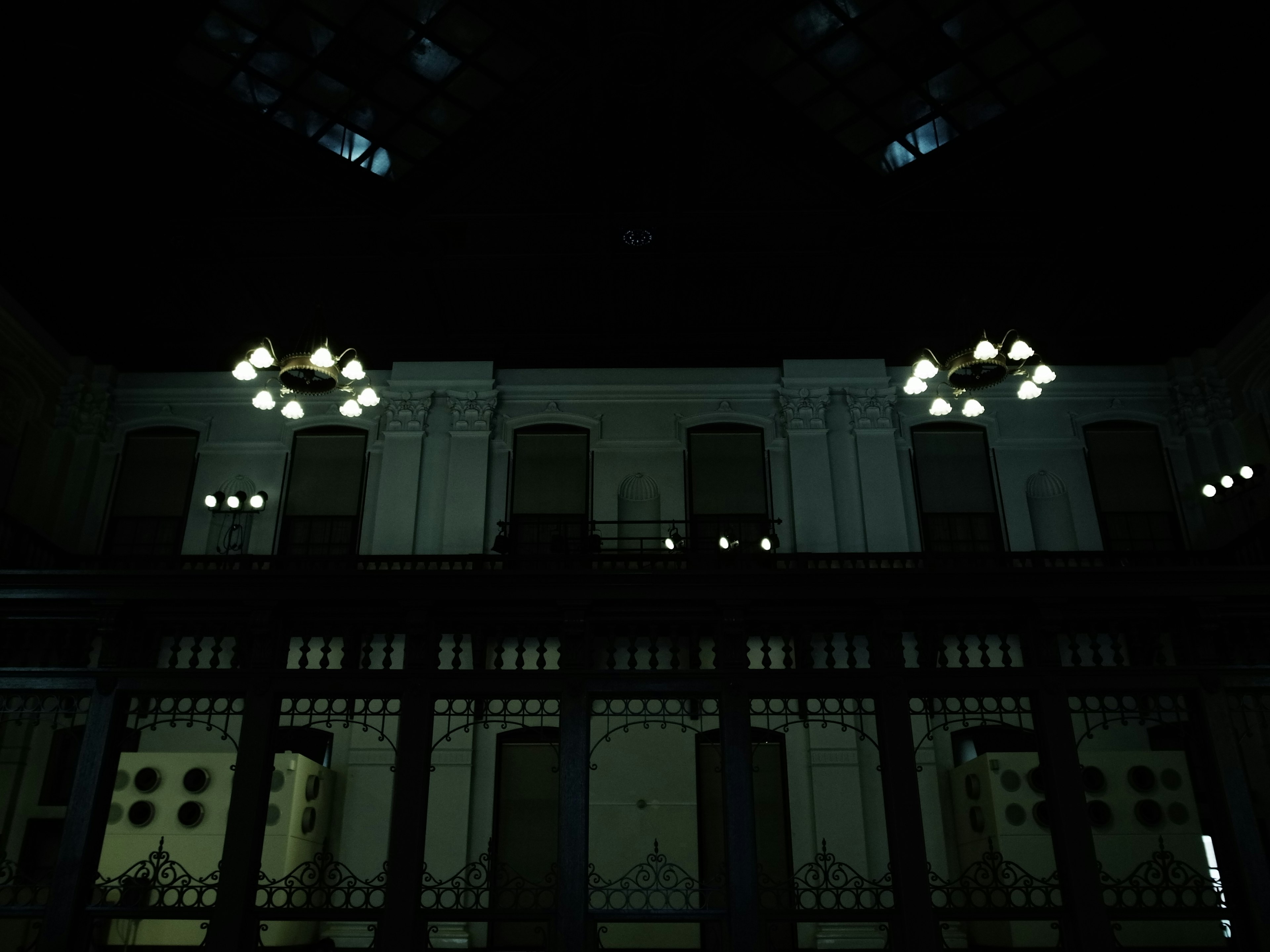 Interior de un edificio antiguo con candelabros en una habitación oscura