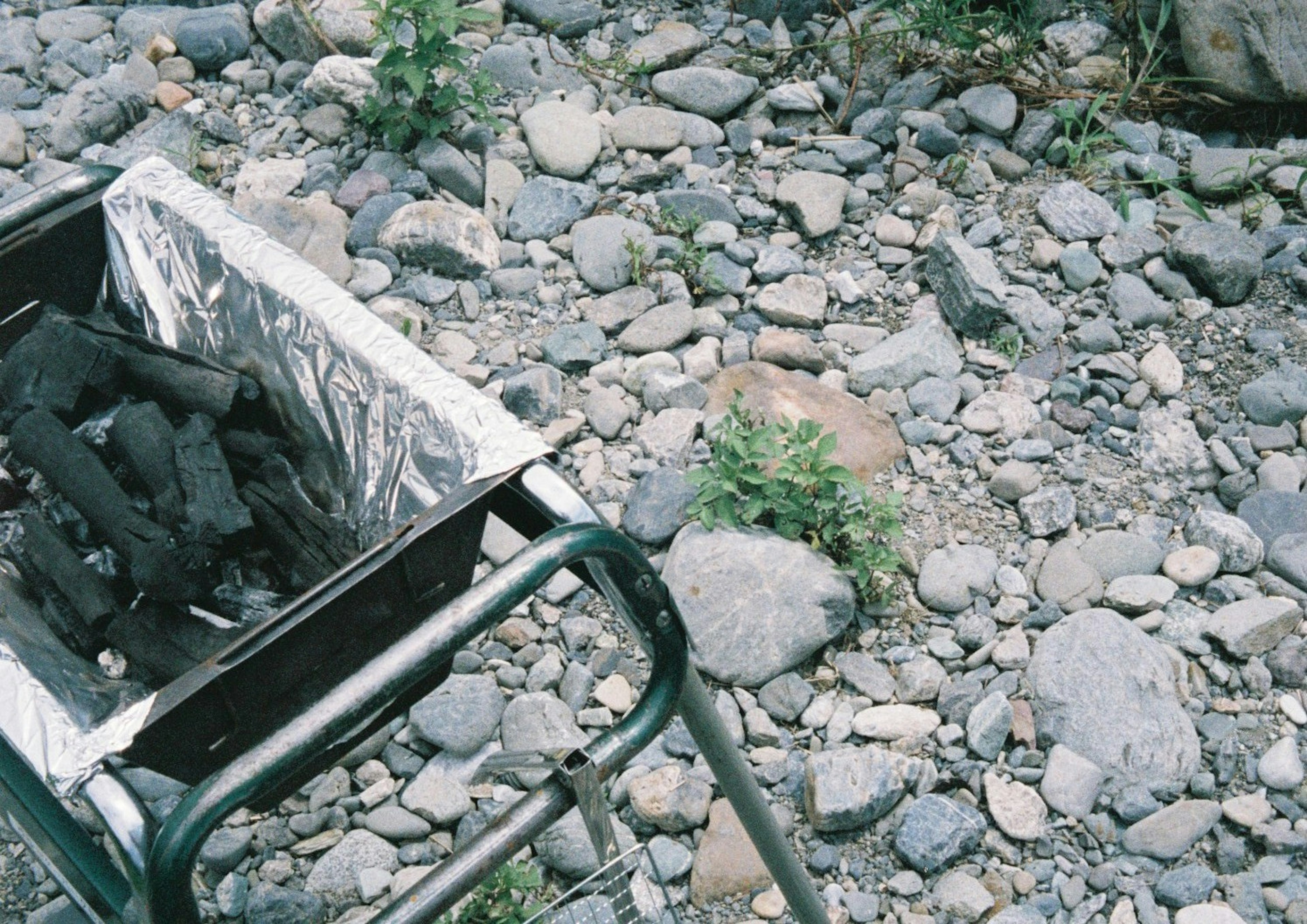 Griglia per barbecue con carbone posizionata su terreno roccioso