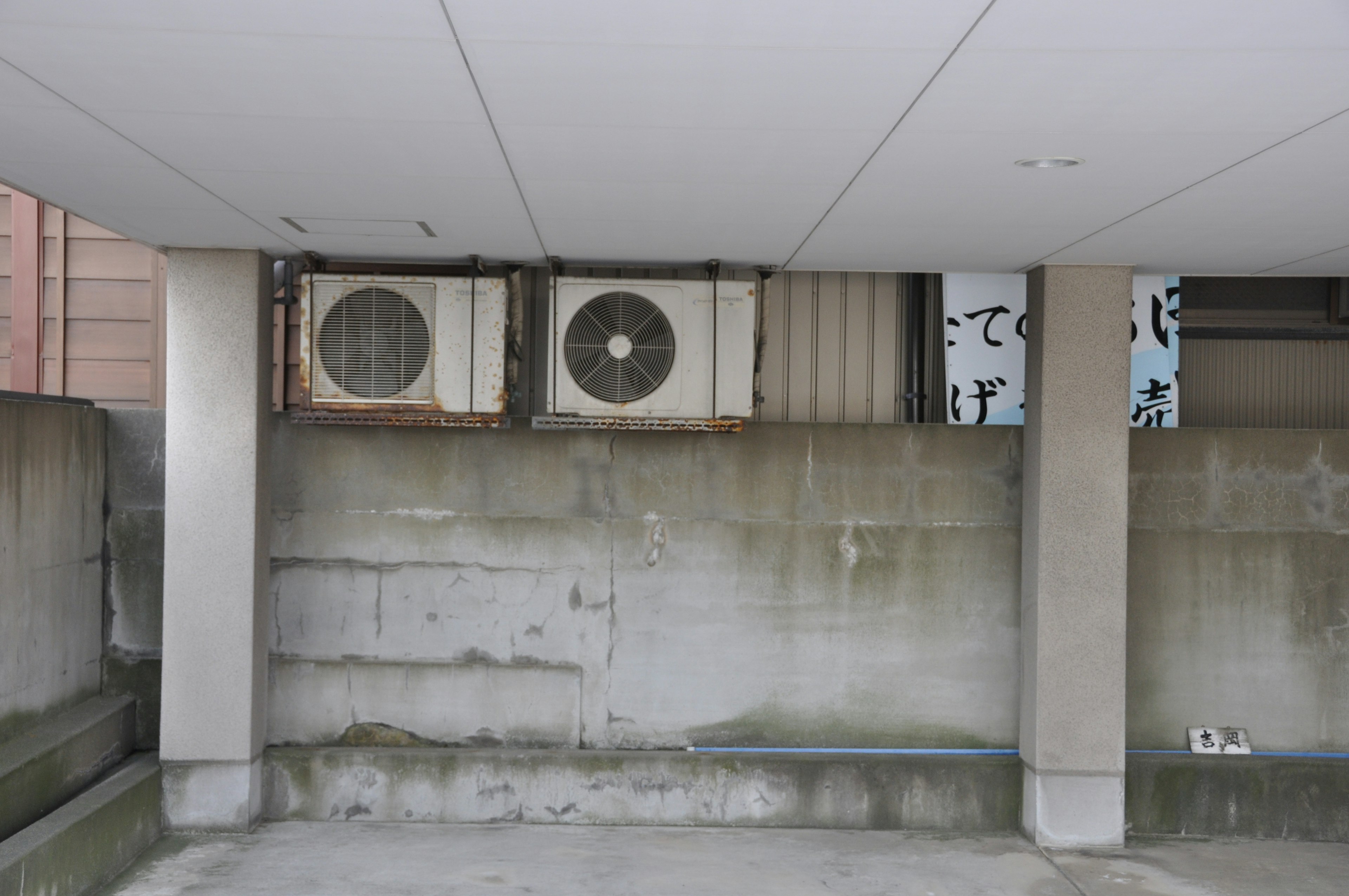 Imagen de unidades de aire acondicionado antiguas montadas en una pared de concreto