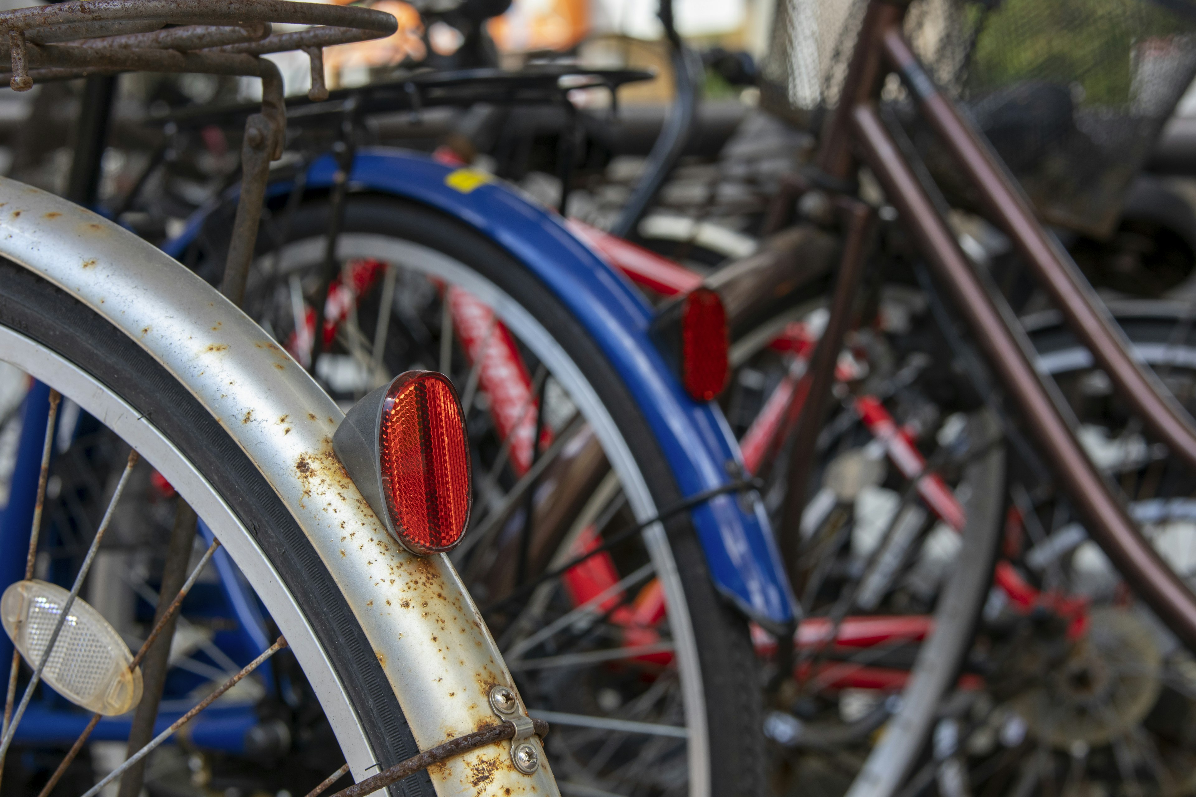 Close-up of bicycle wheels with red reflectors and a mix of colors