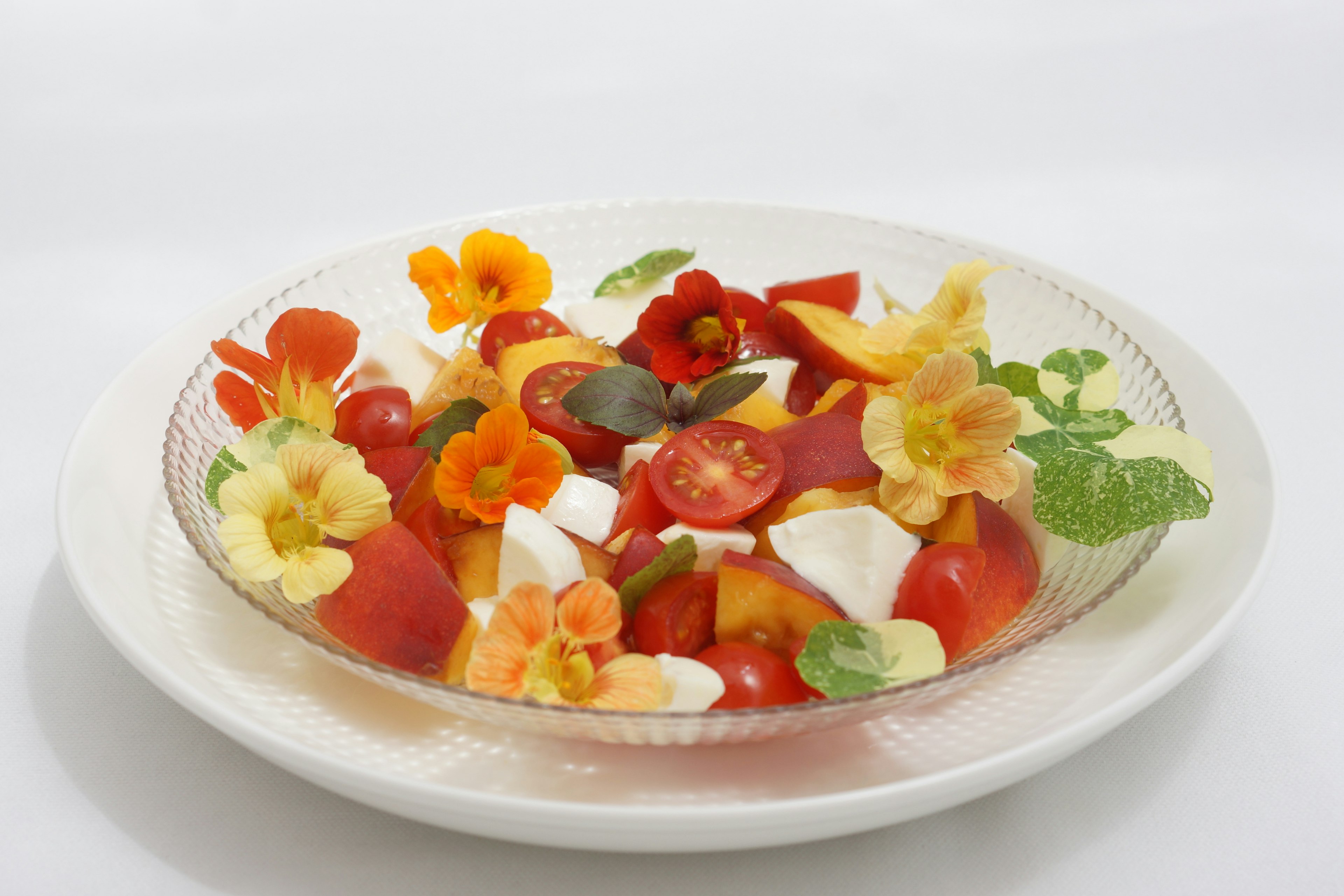 Colorful fruit salad garnished with edible flowers