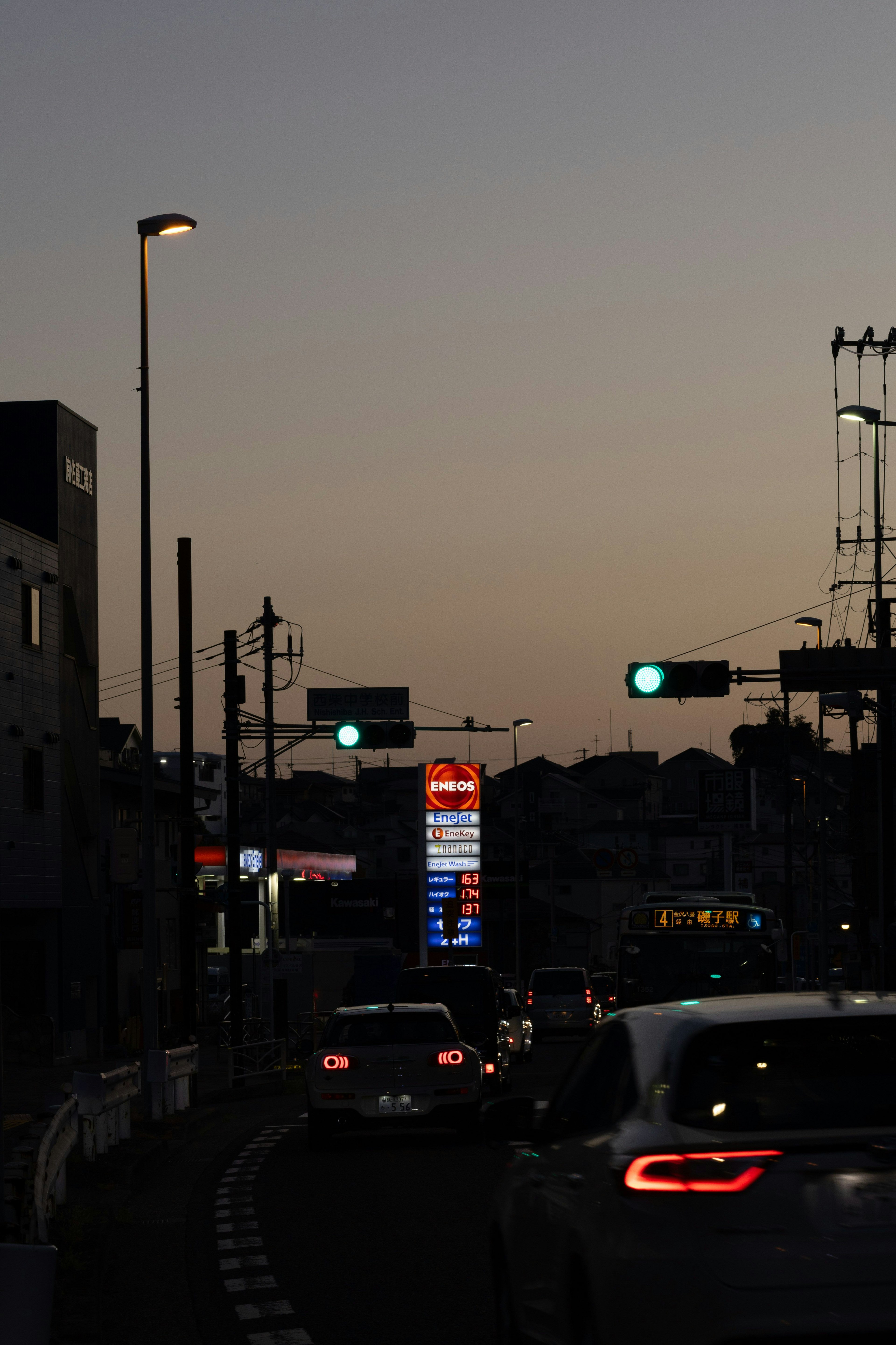 夕暮れ時の街道に並ぶ車と信号機の光