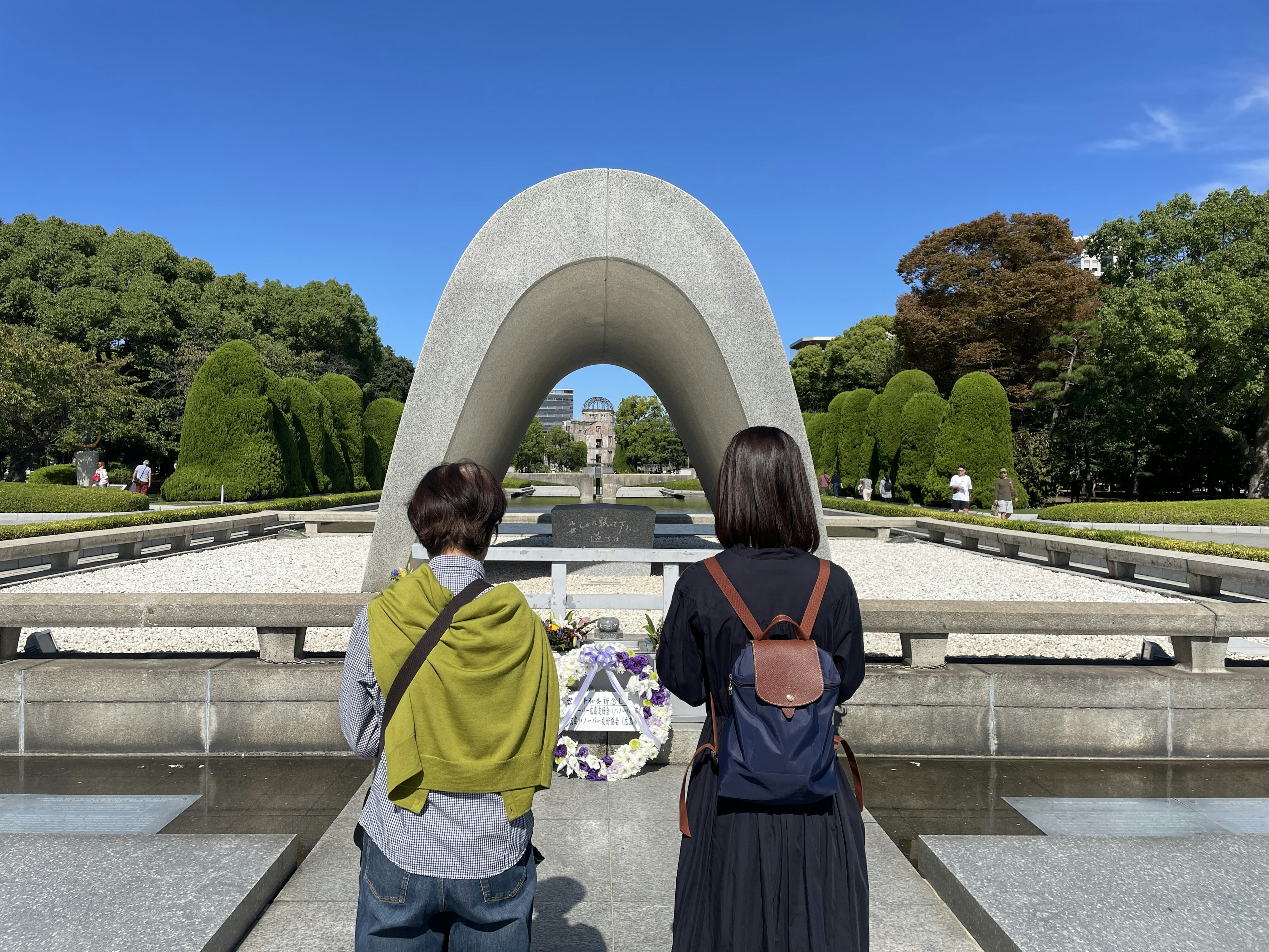 Deux personnes regardant un monument en forme d'arc dans un parc