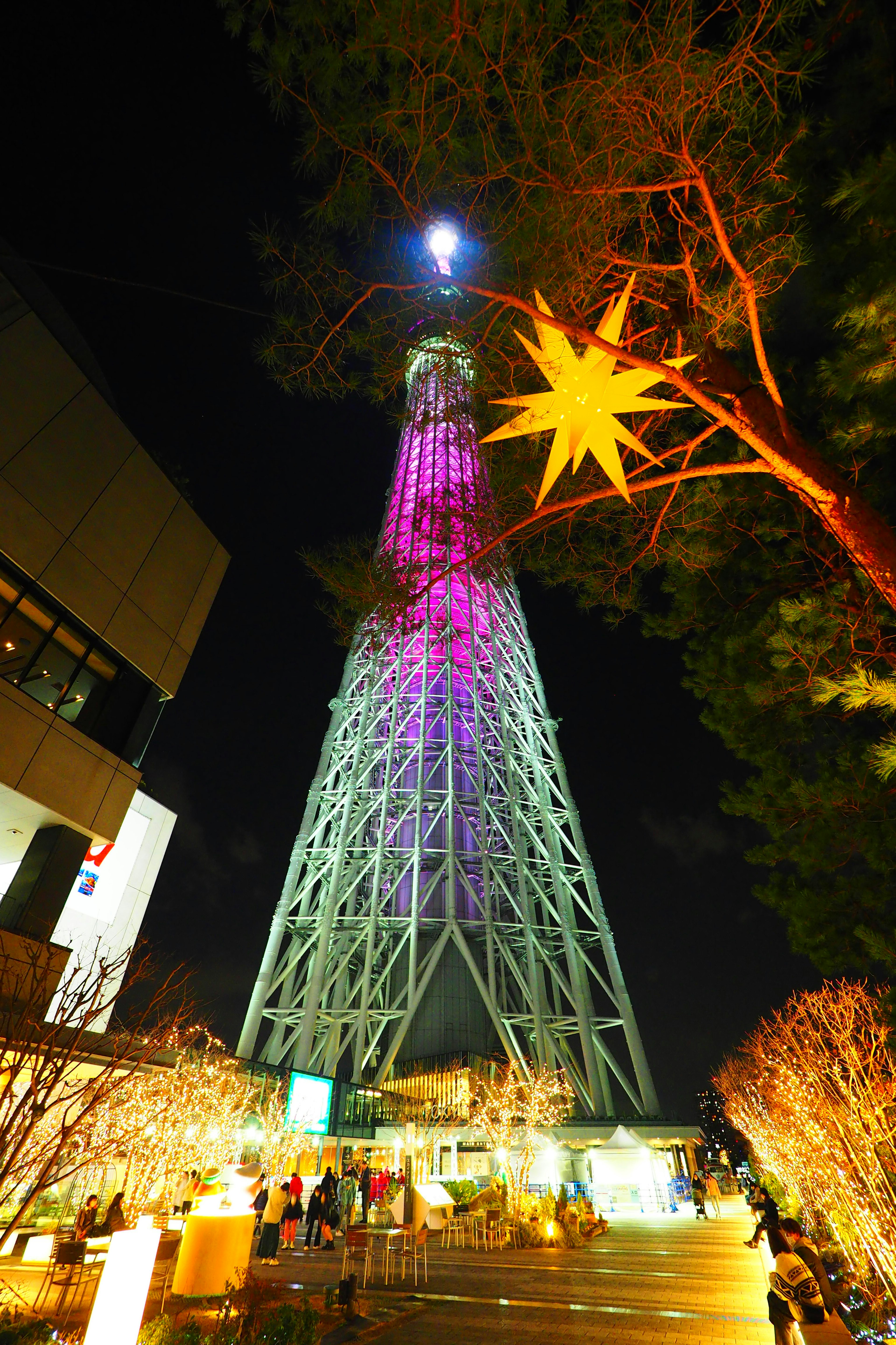 โตเกียวสกายทรีสว่างไสวในตอนกลางคืนพร้อมแสงสีและทิวทัศน์โดยรอบ