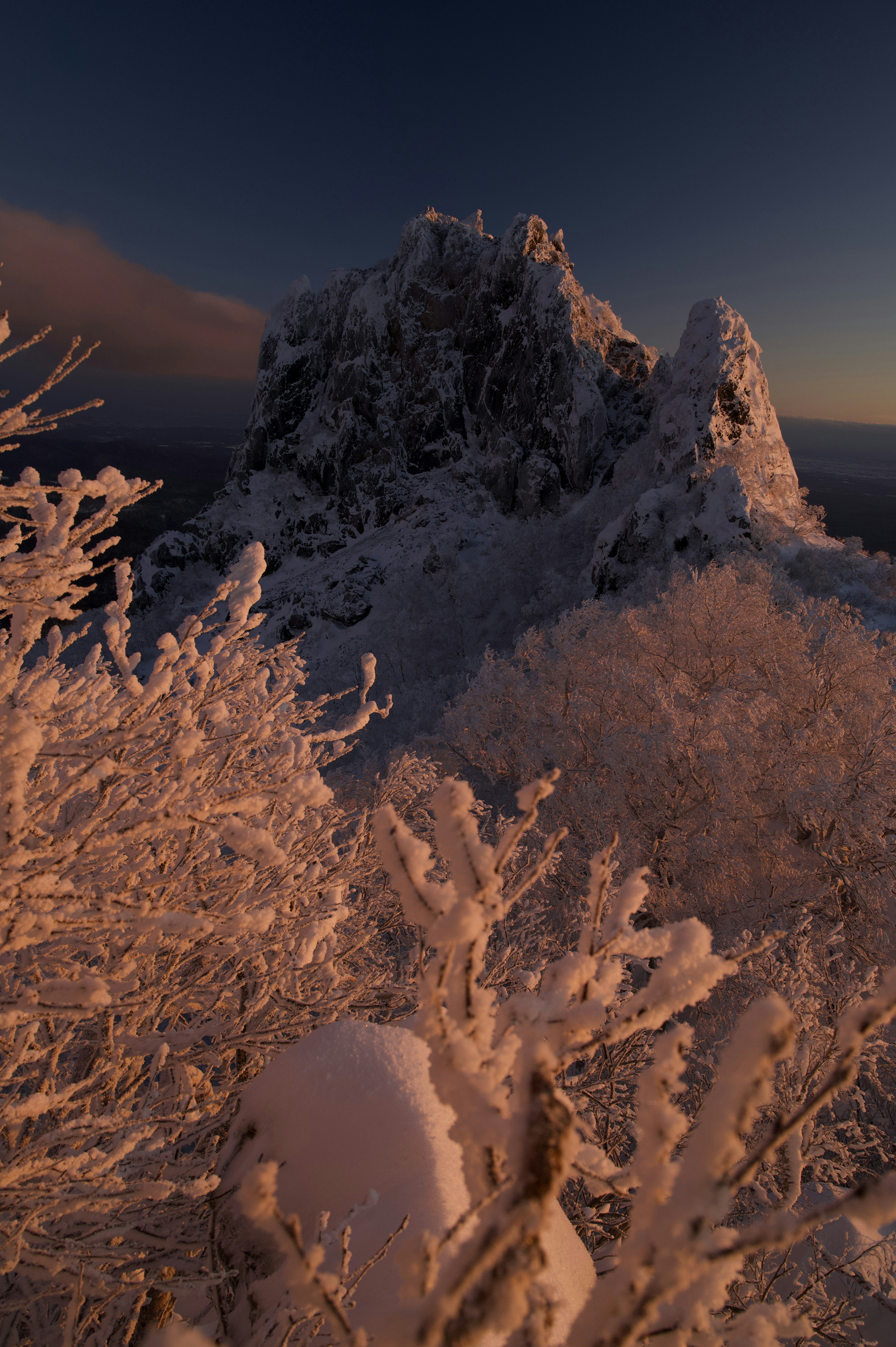 Paisaje montañoso cubierto de nieve con un cielo al amanecer