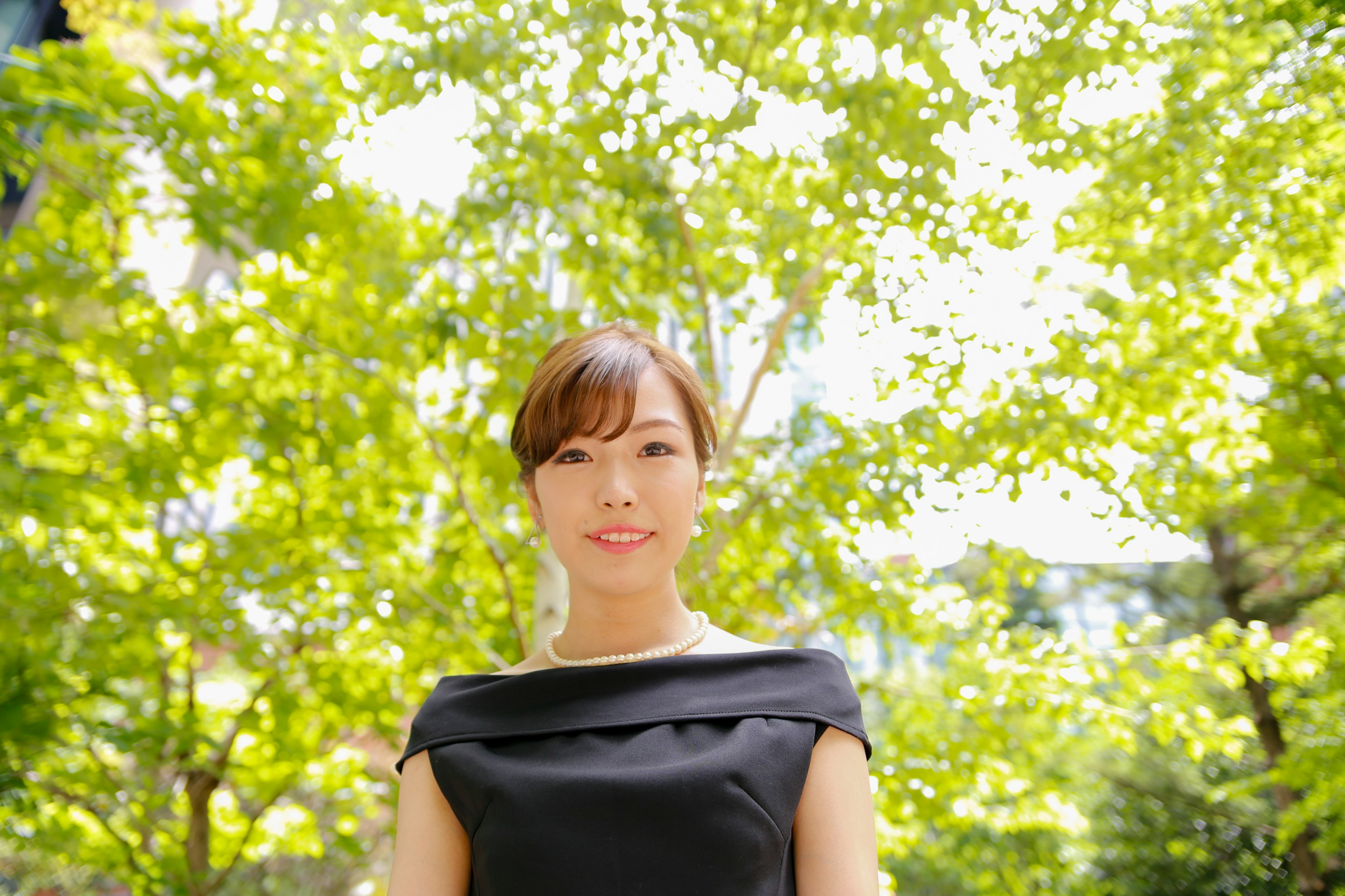 Portrait d'une femme se tenant parmi des arbres verts