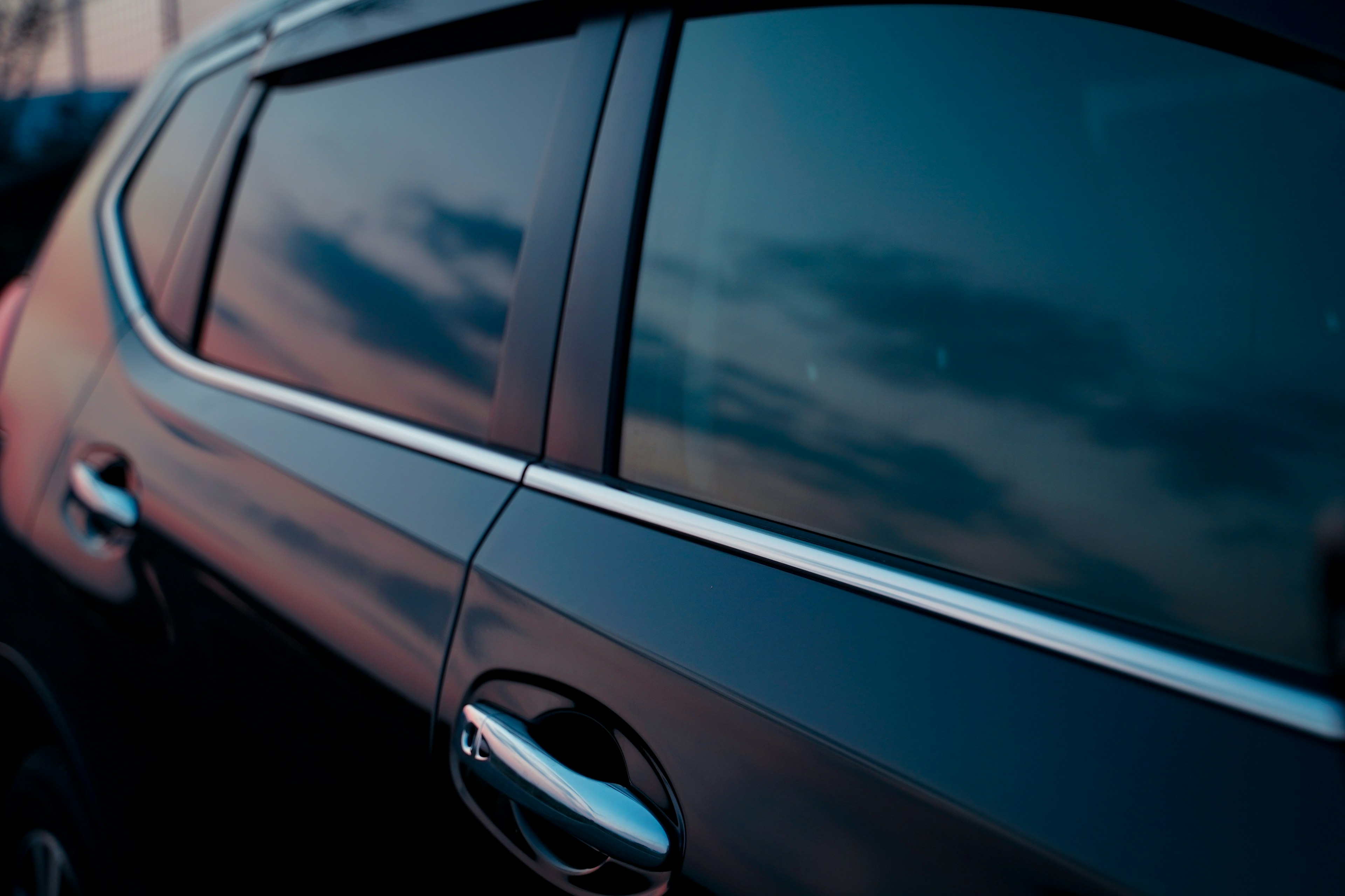 Reflexion des Himmels und der Wolken auf einem schwarzen Autofenster