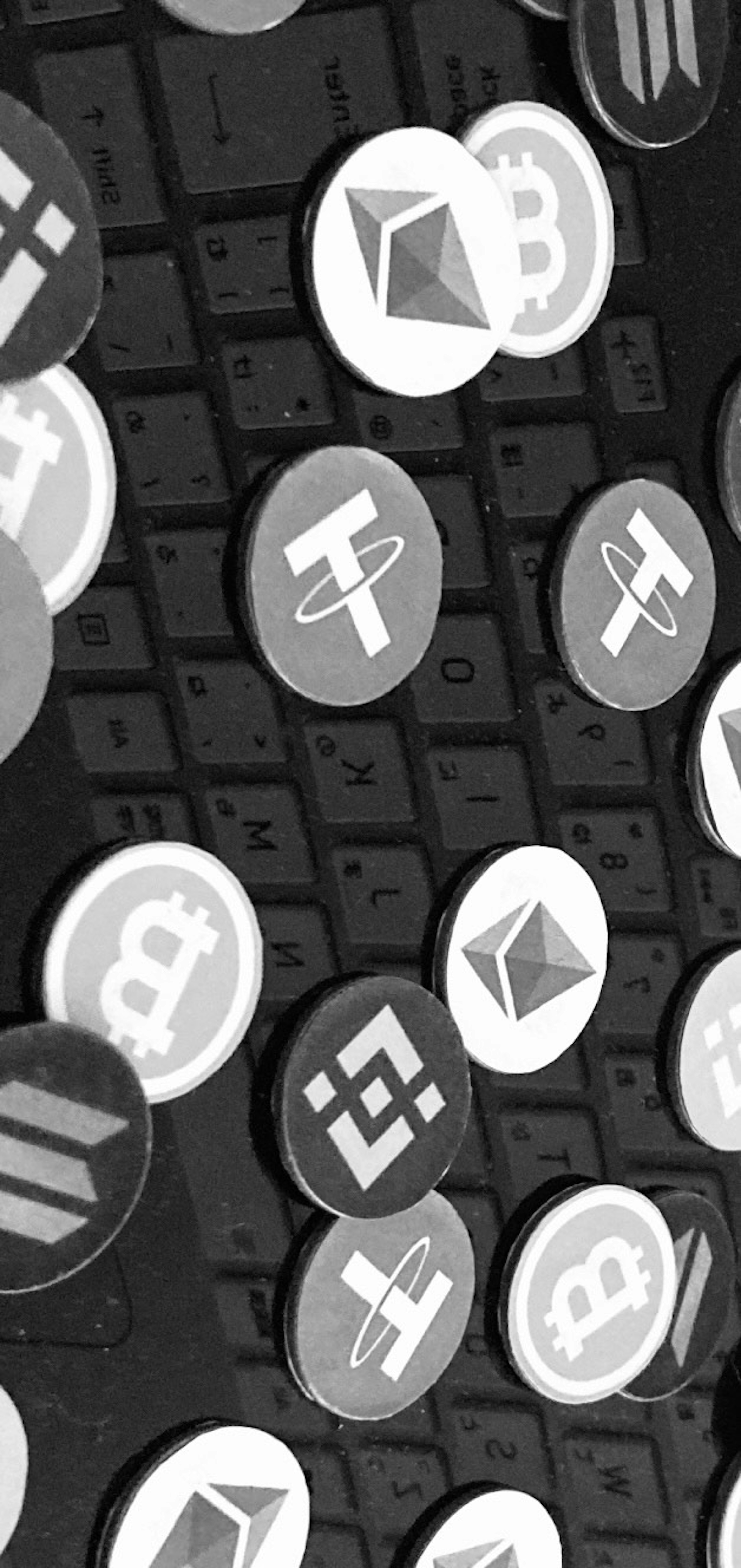 Monedas de criptomonedas esparcidas sobre un teclado negro