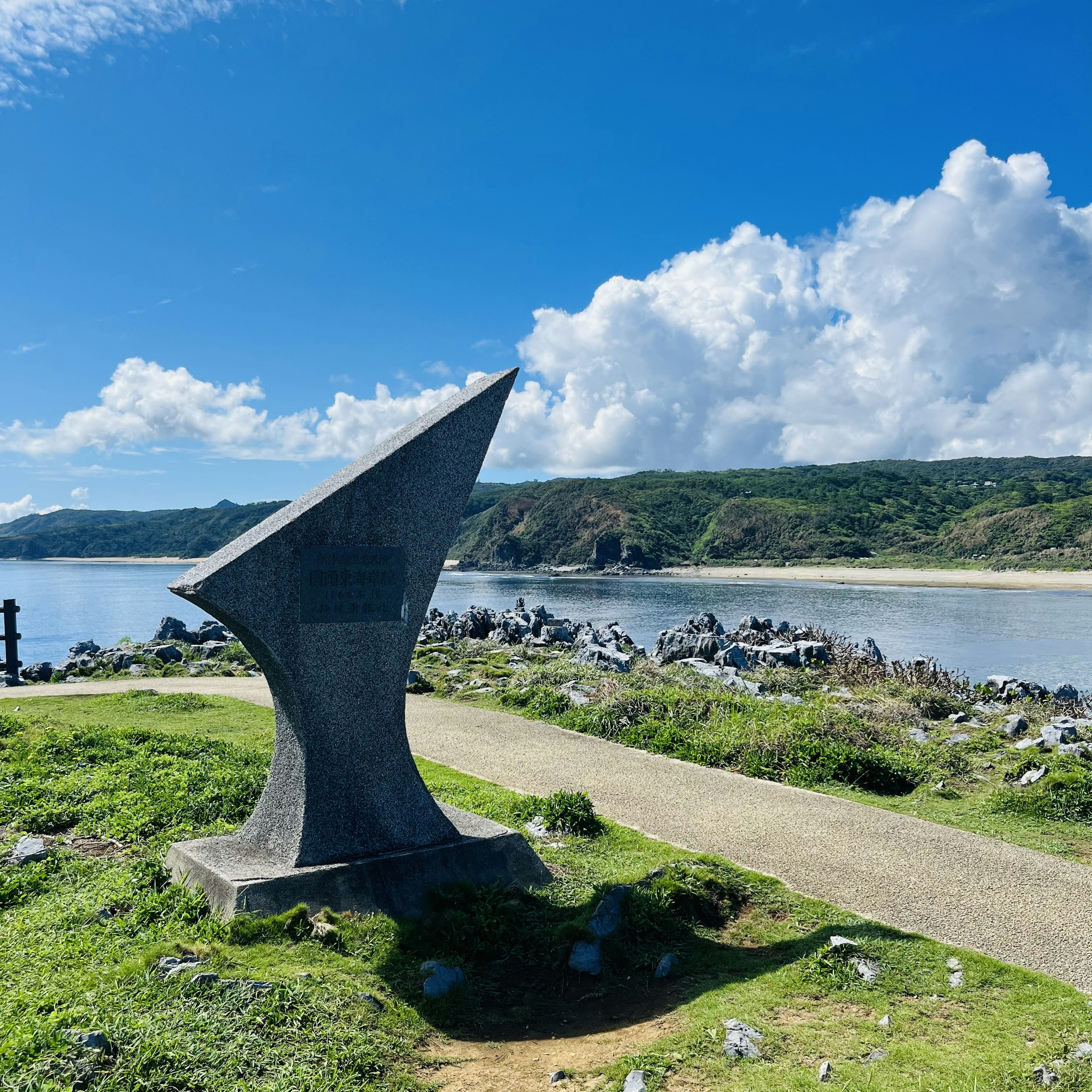 Patung modern di pantai dengan langit biru