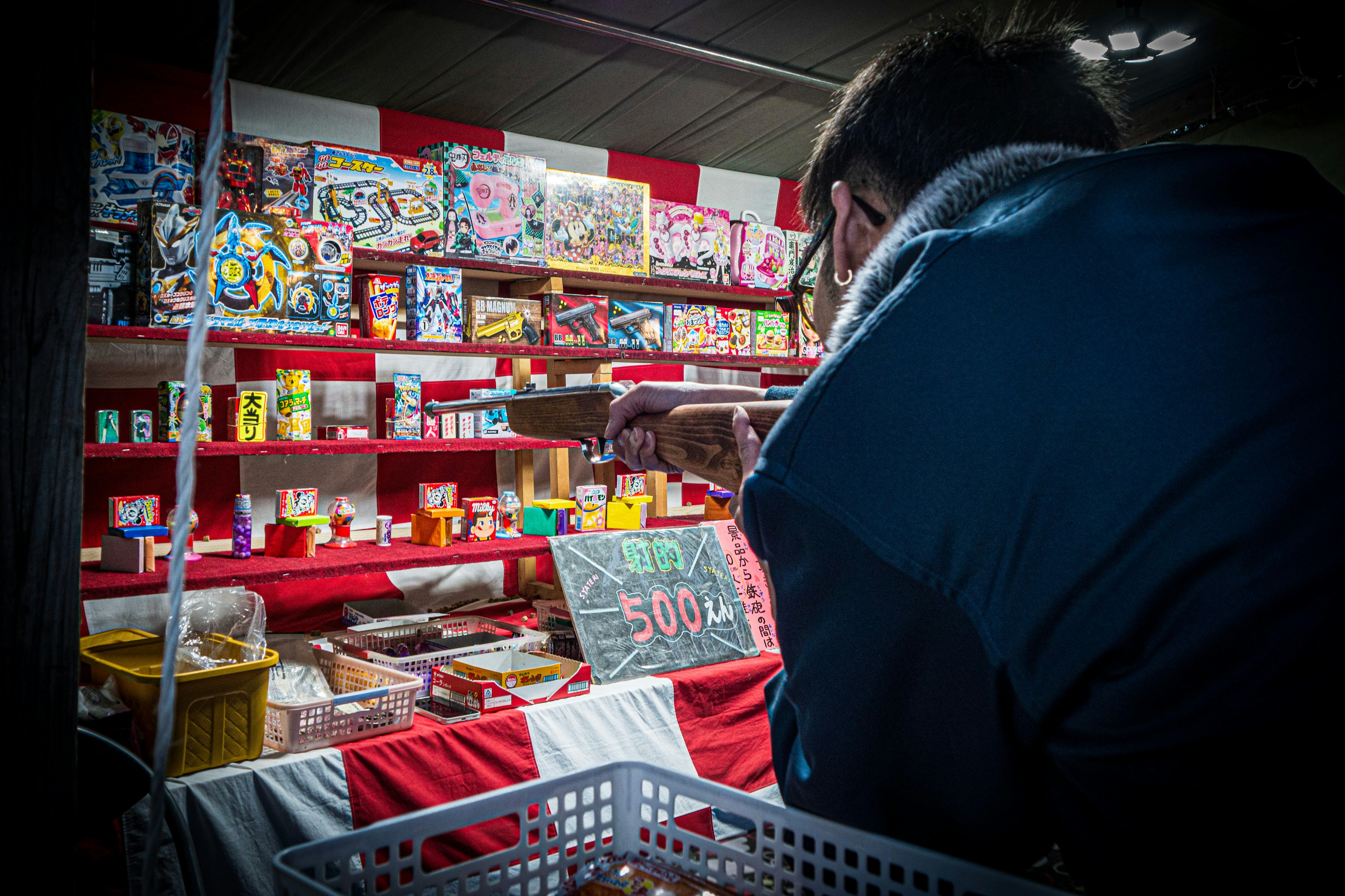 Eine Person wählt Artikel in einem Spielzeugladen aus bunte Kisten und Snacks sind auf den Regalen ausgestellt