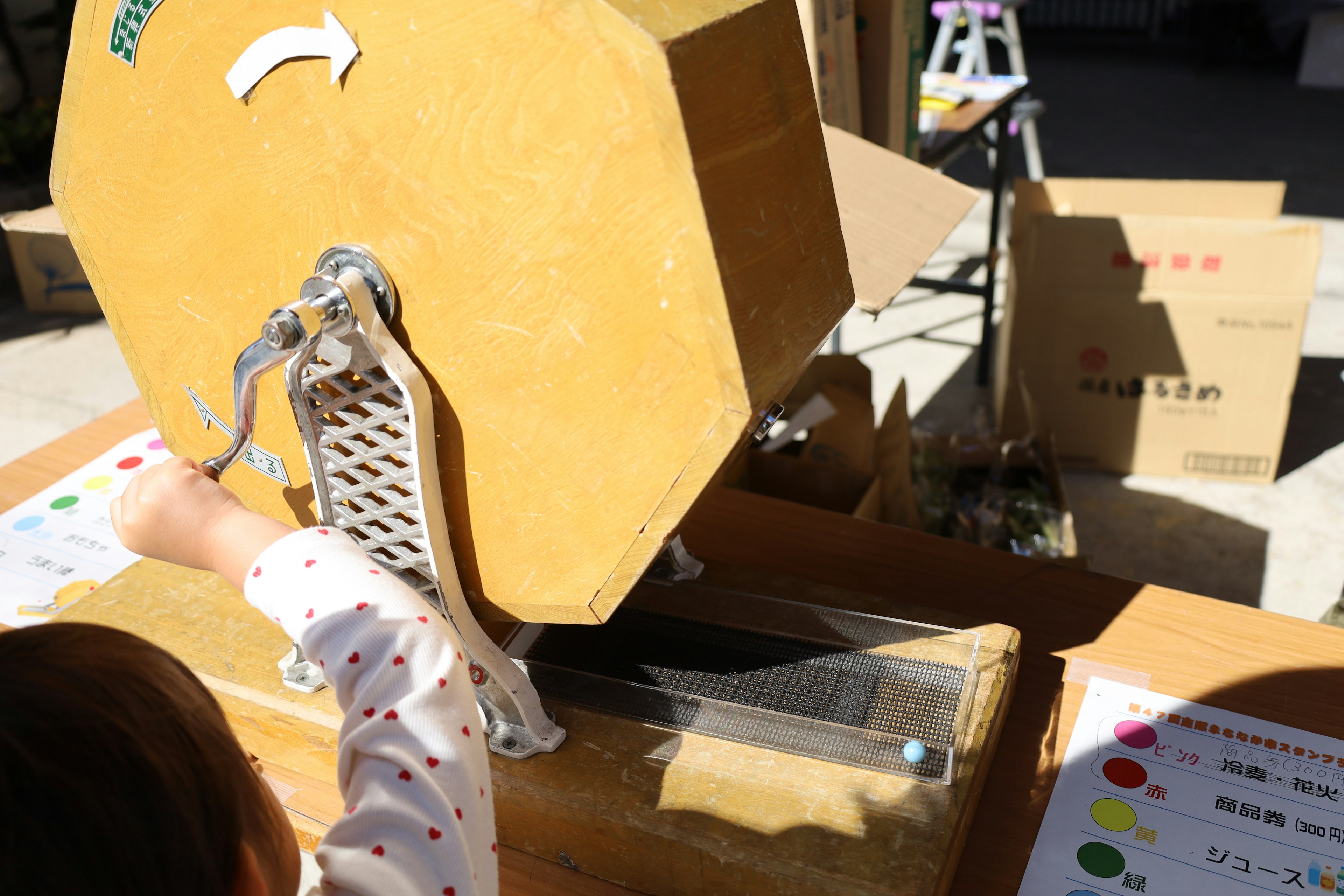 A child operating a manual lottery wheel