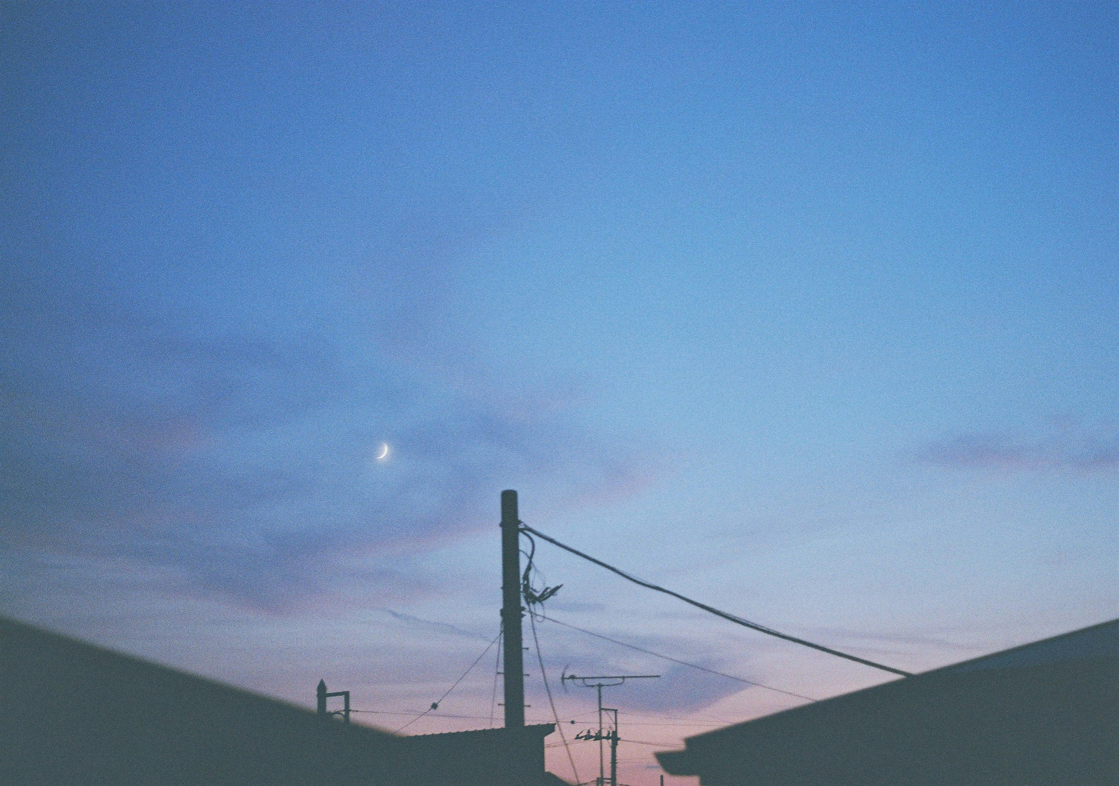 青い空に薄い雲と月が見える夕暮れの風景