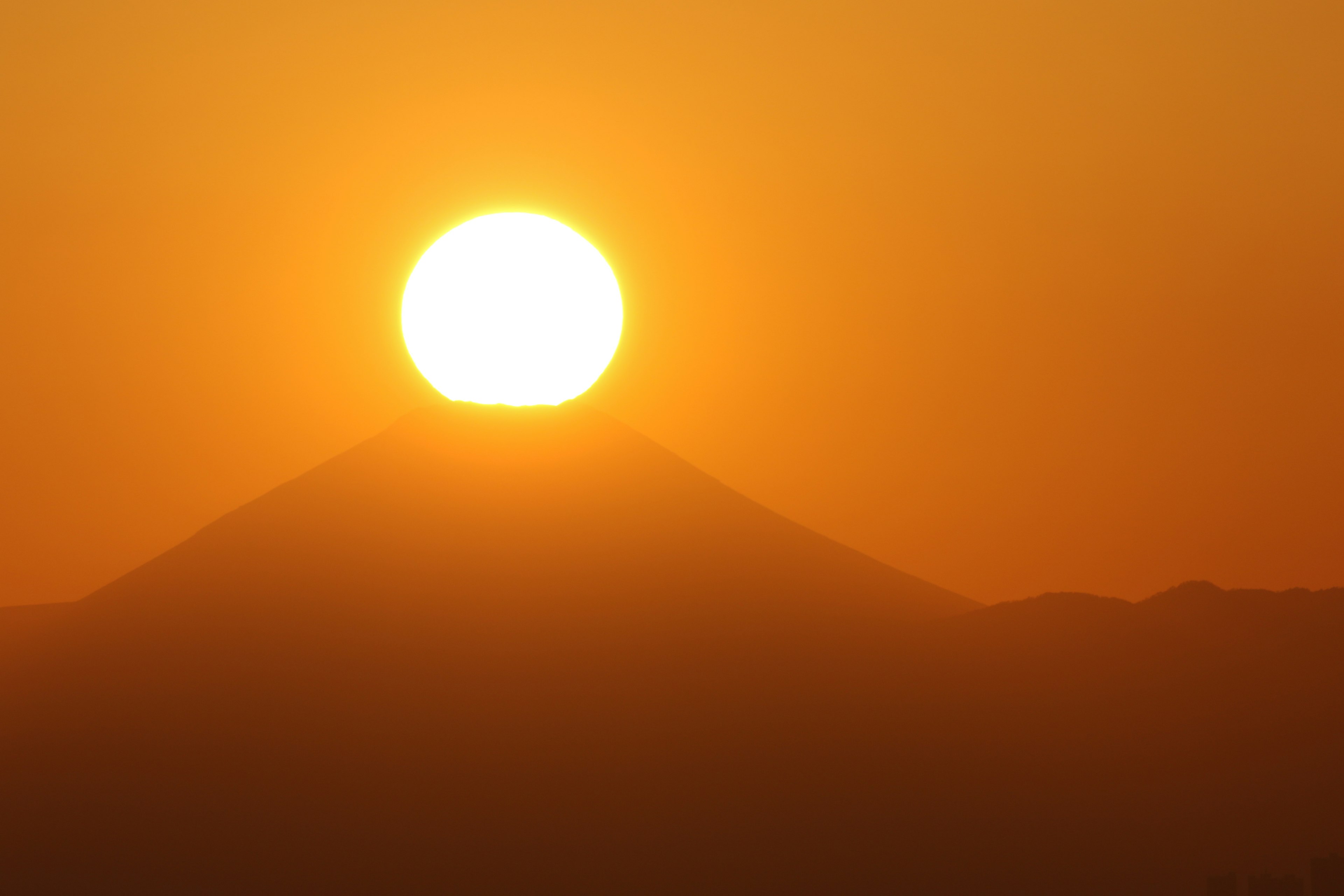 A sunset over a mountain silhouette