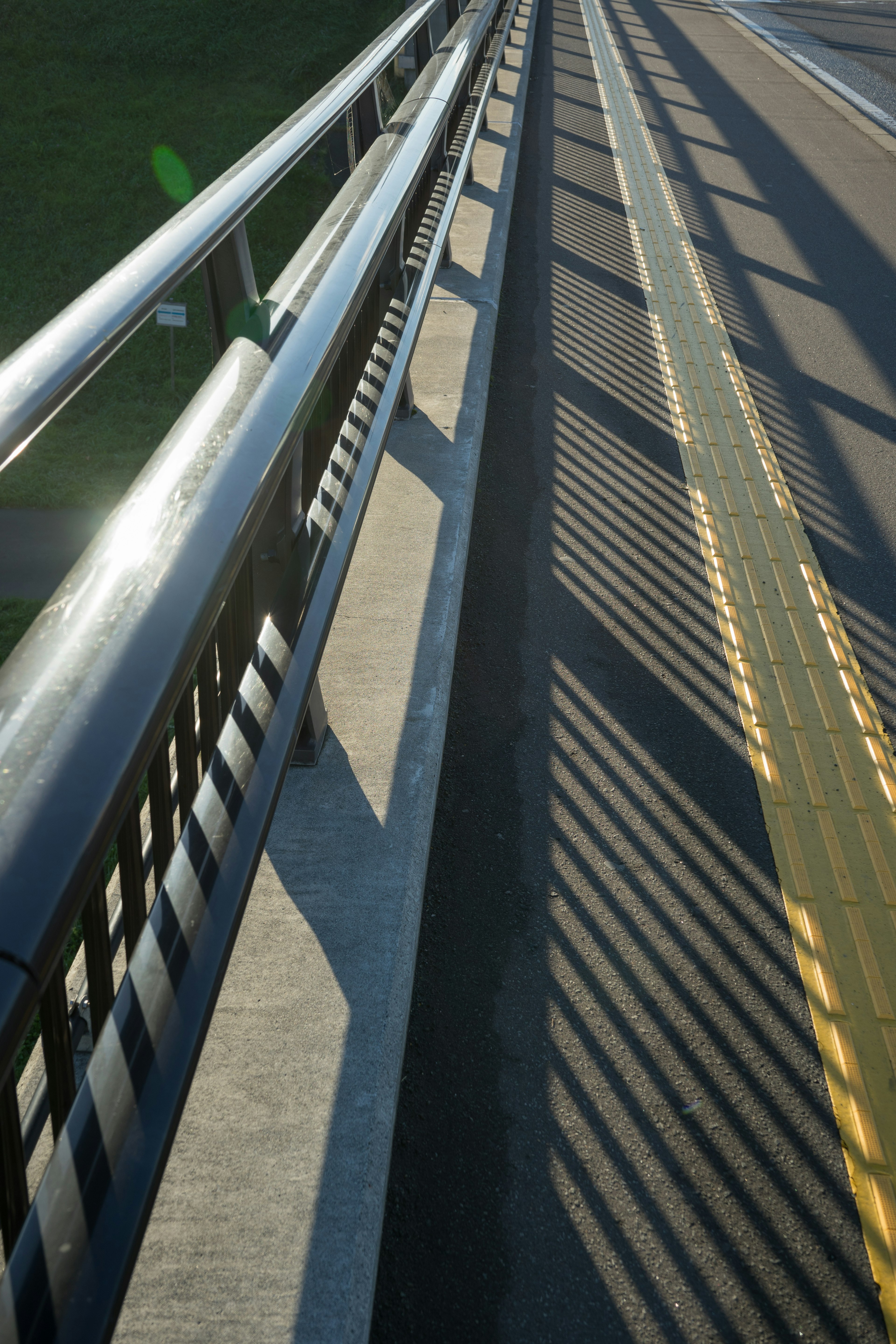 Abschnitt einer Straße mit einem Geländer und Schatten