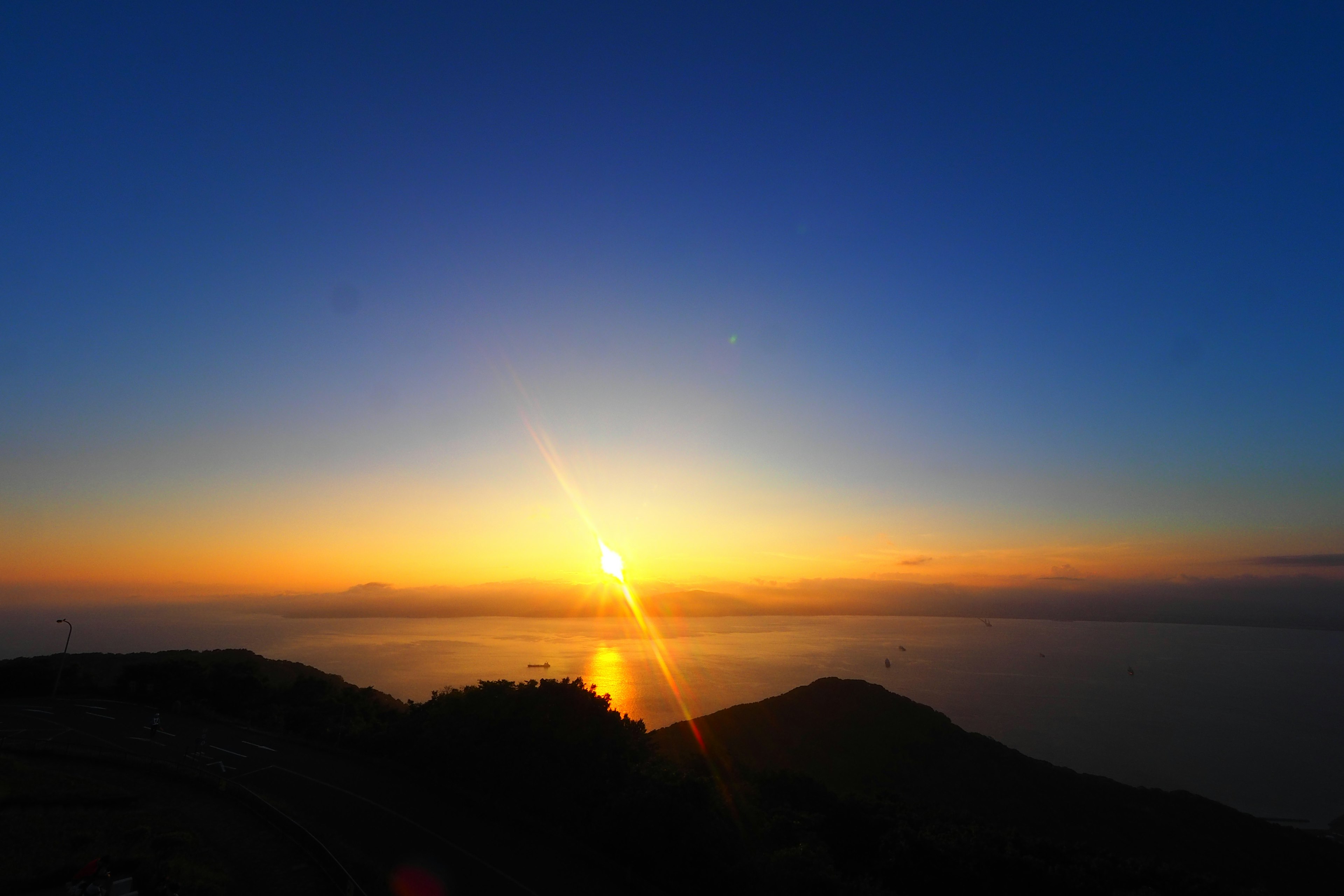 A beautiful sunset over the ocean with mountain silhouettes