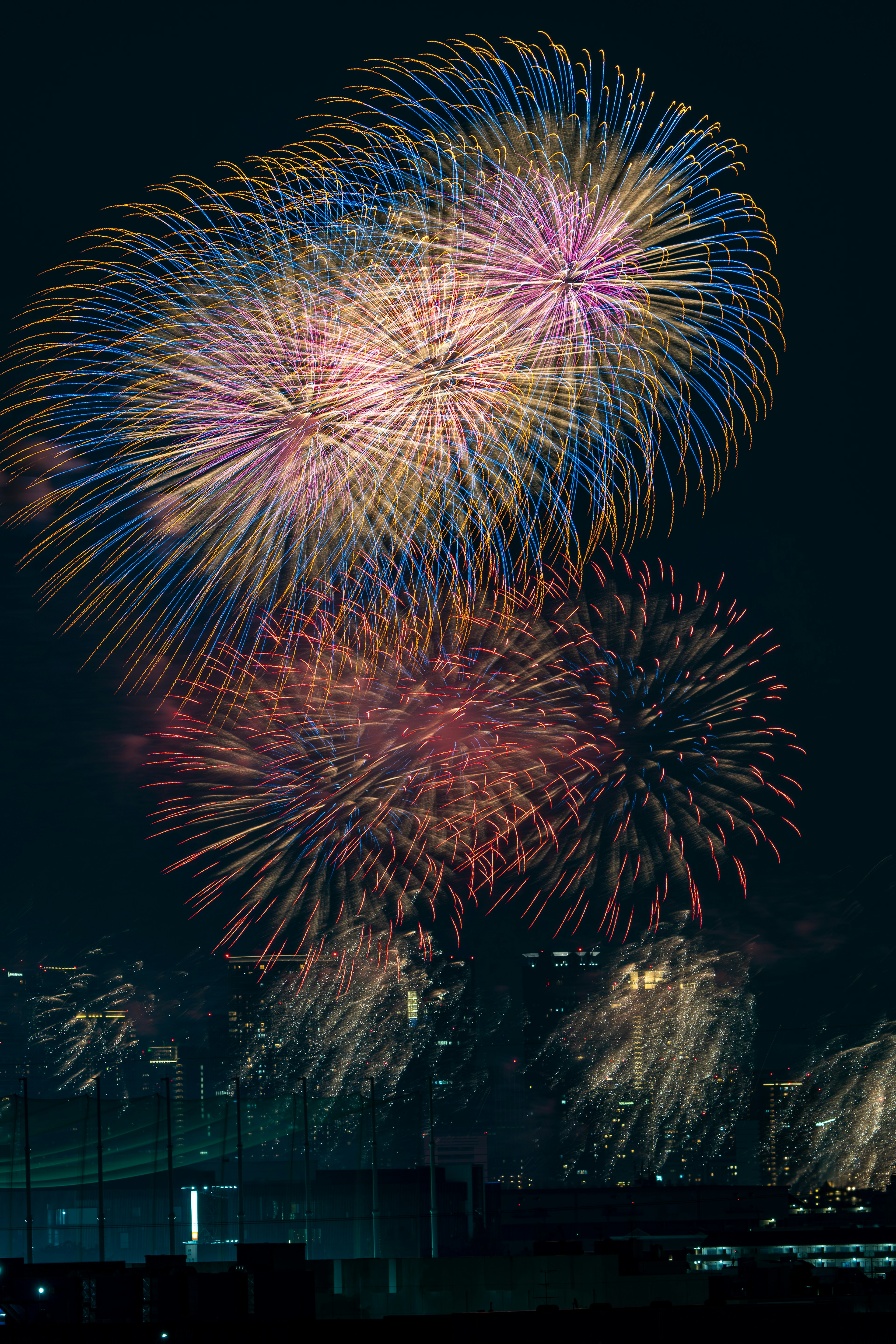 夜空に咲く色とりどりの花火が美しく輝いている場面