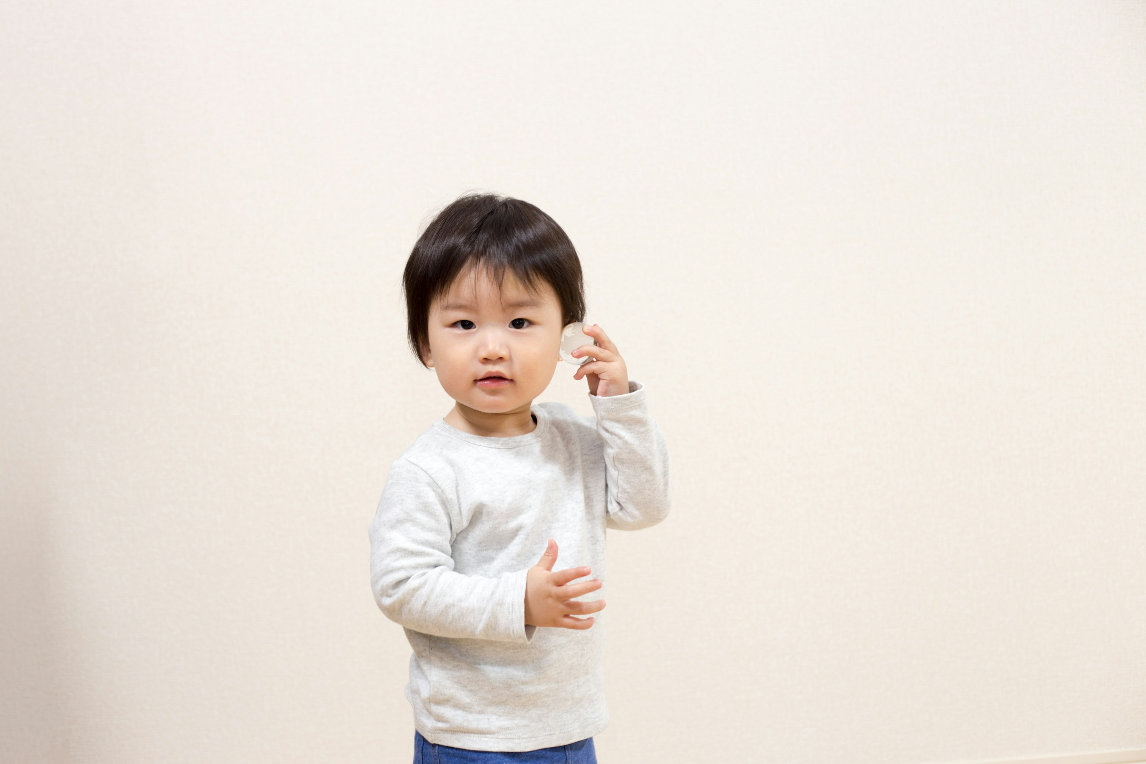 하얀 벽 앞에서 포즈를 취하는 어린 소년