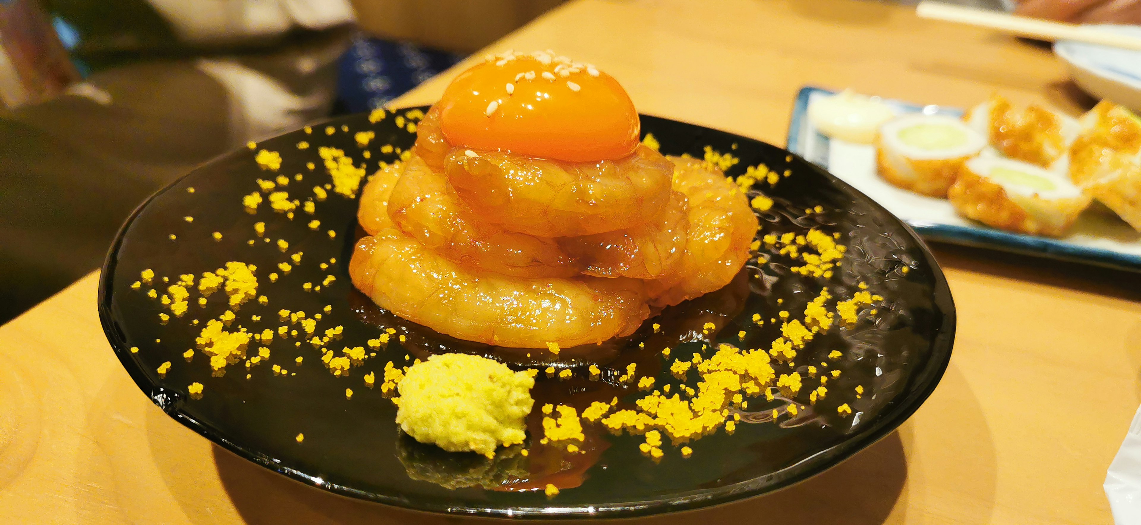 Montículo de postre dulce en un plato negro con polvo amarillo