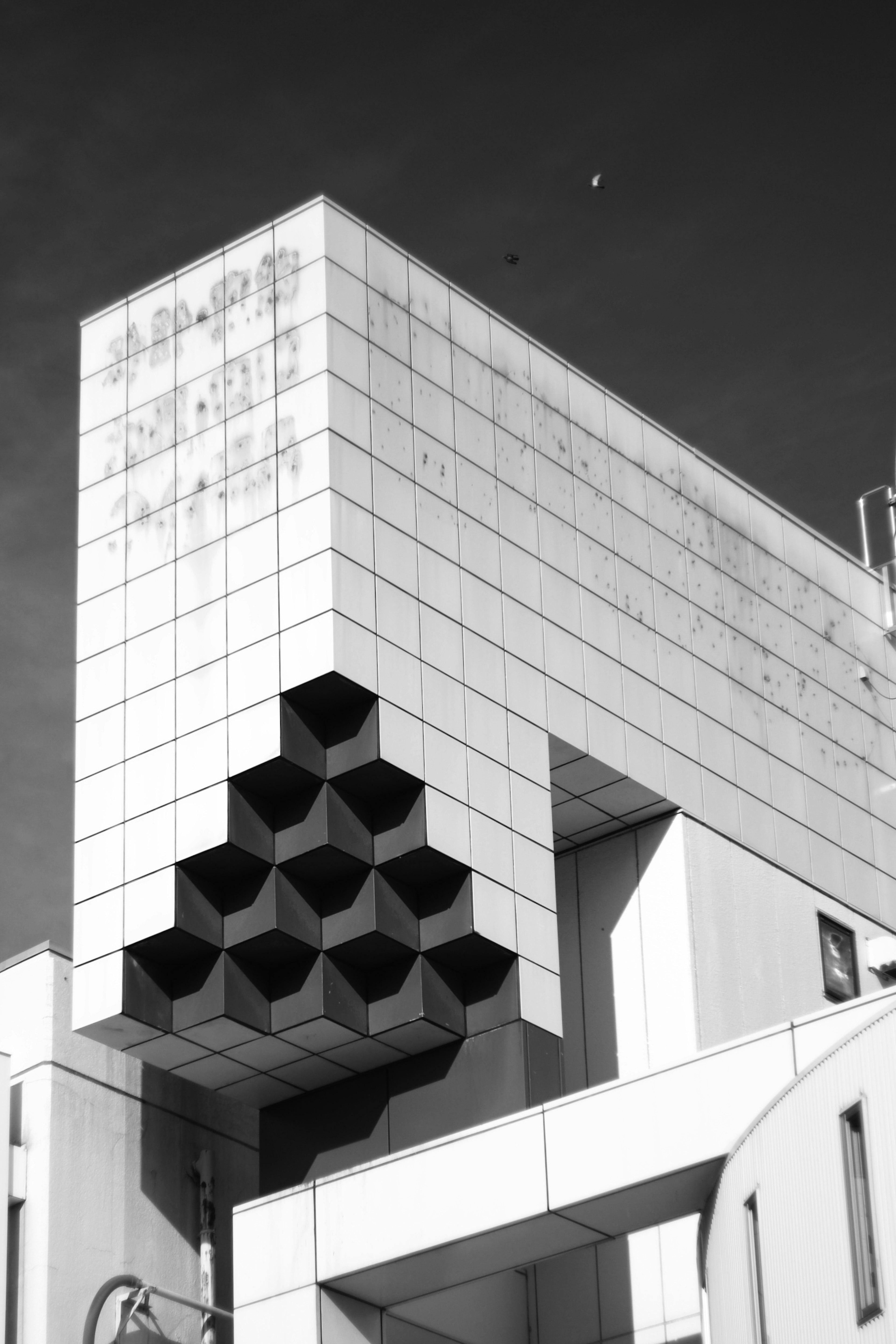 Fachada de edificio con patrón geométrico único en foto en blanco y negro de arquitectura moderna