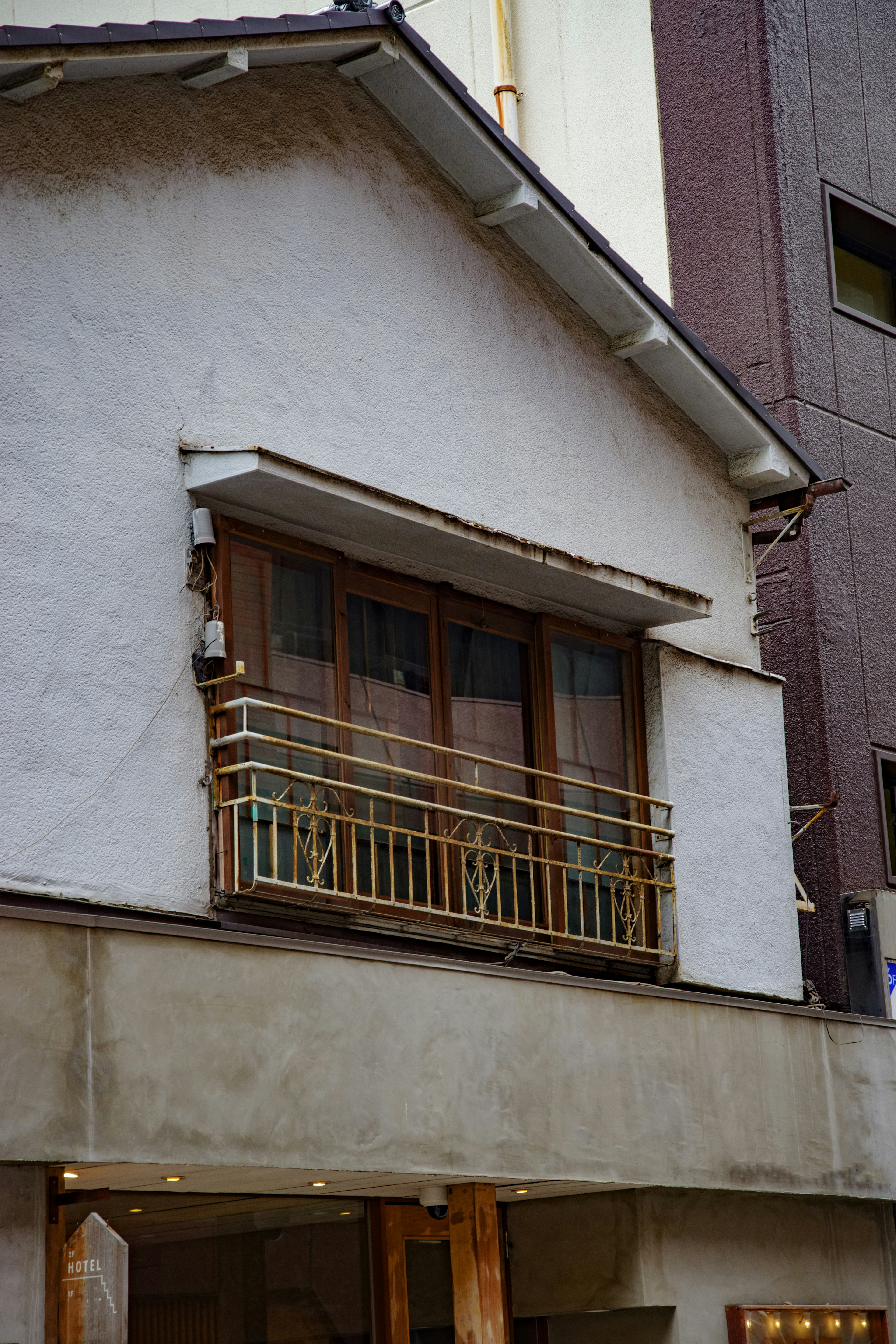 Maison à l'extérieur blanc avec un balcon et des fenêtres en bois