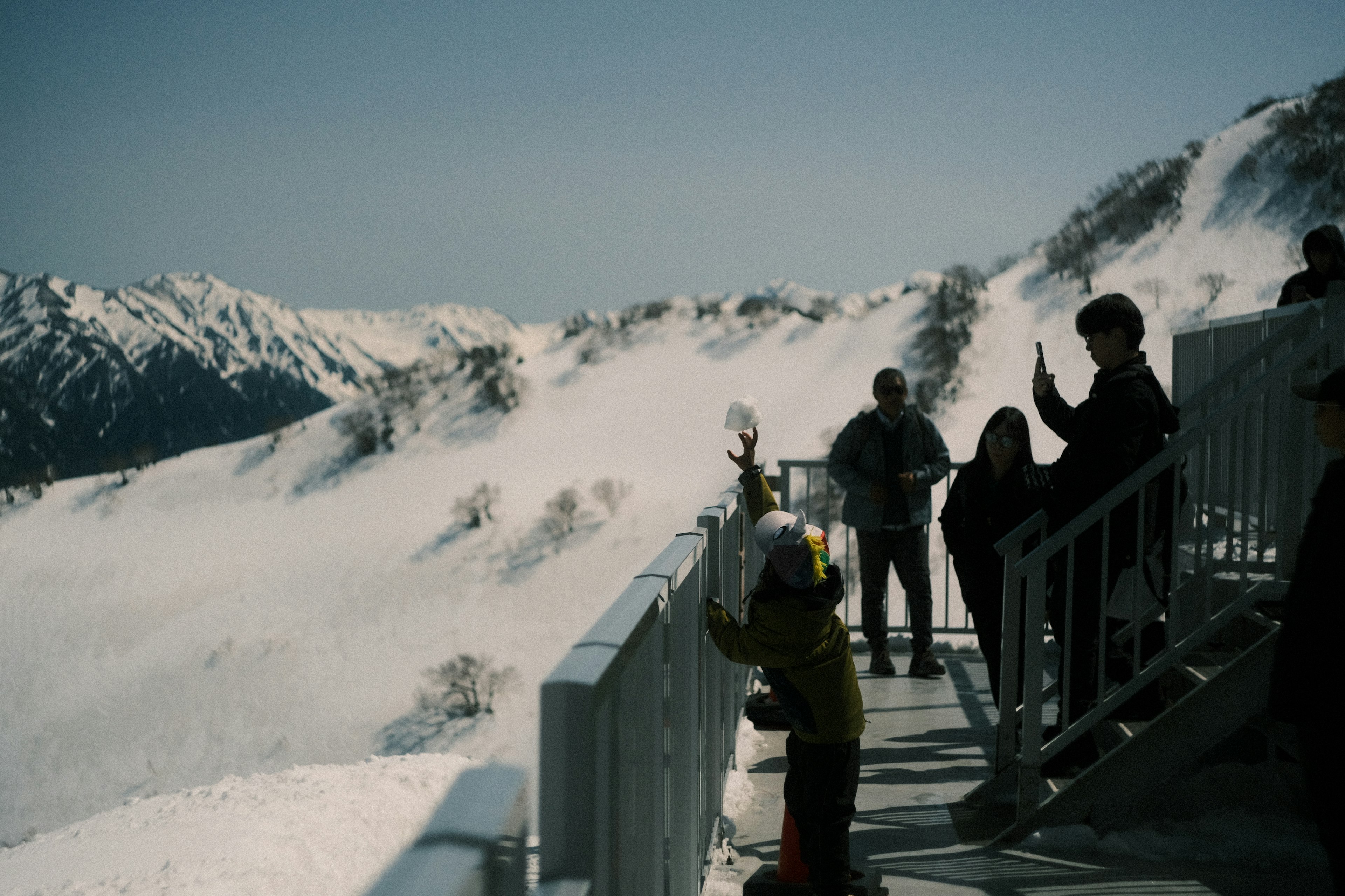 Touristen genießen die Aussicht auf den verschneiten Berg