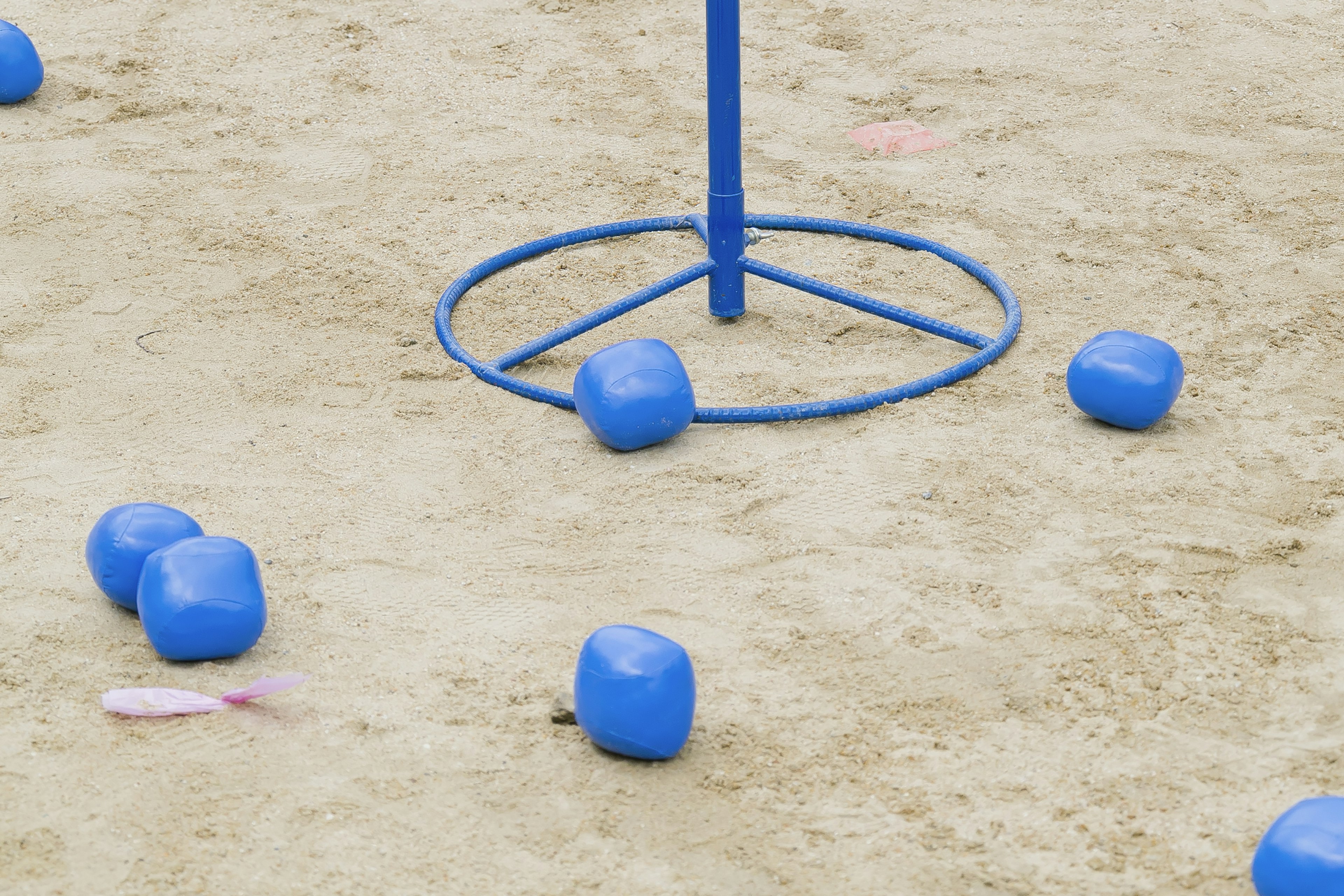 Blue balls and blue frame on sandy ground game