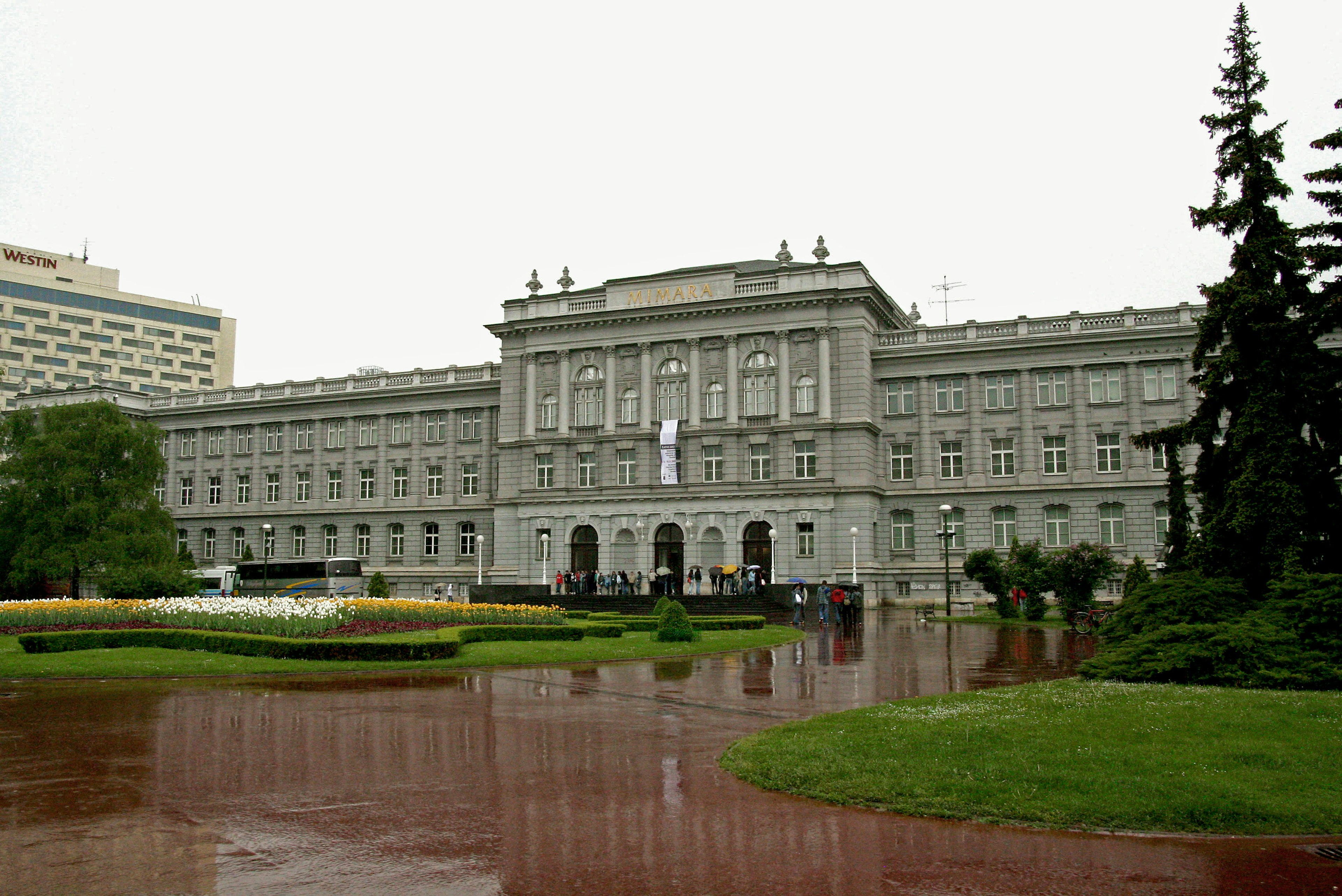 Un gran edificio rodeado de un jardín exuberante en un parque