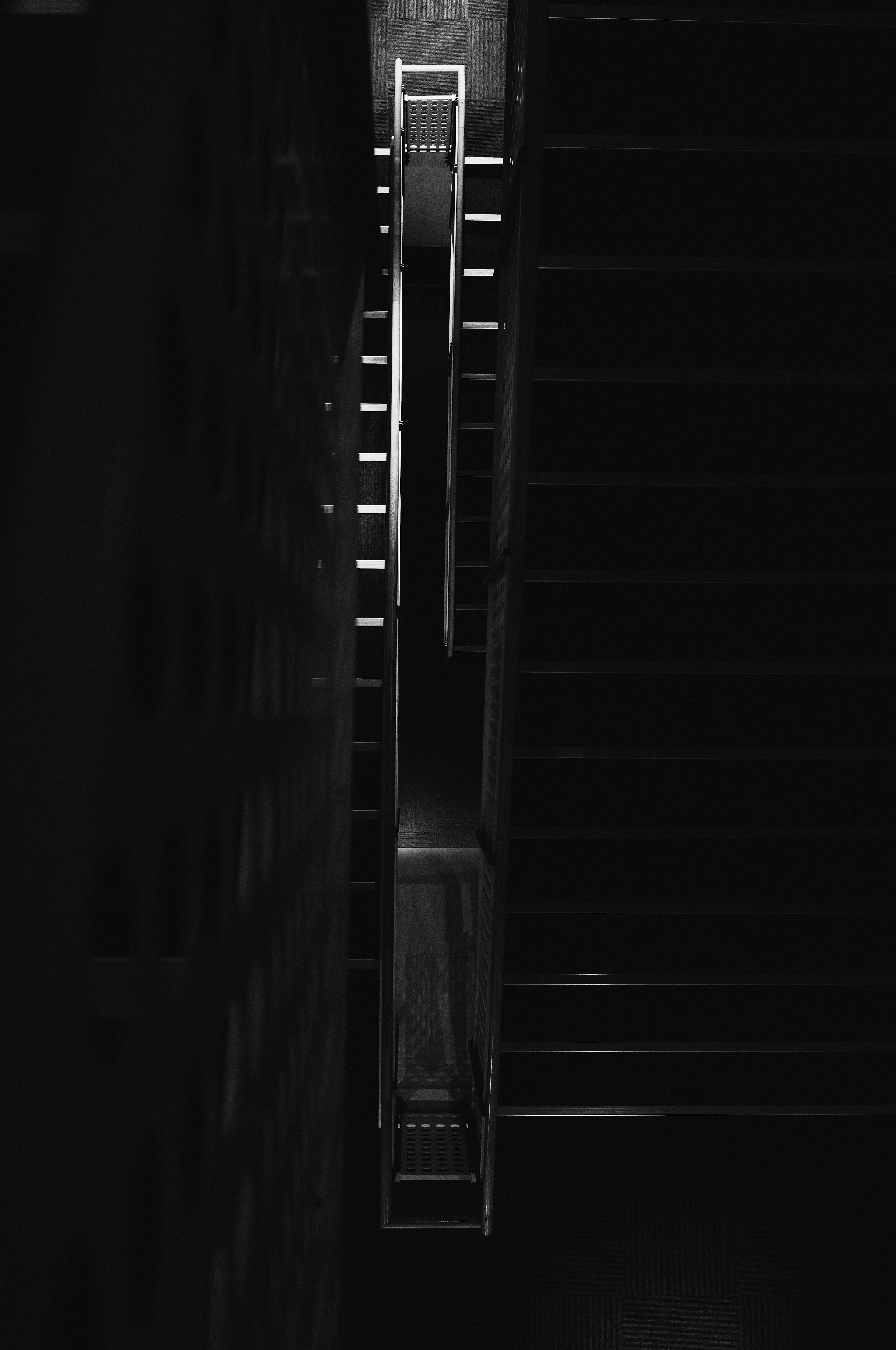 Foto en blanco y negro de una escalera vista desde arriba con un diseño simple