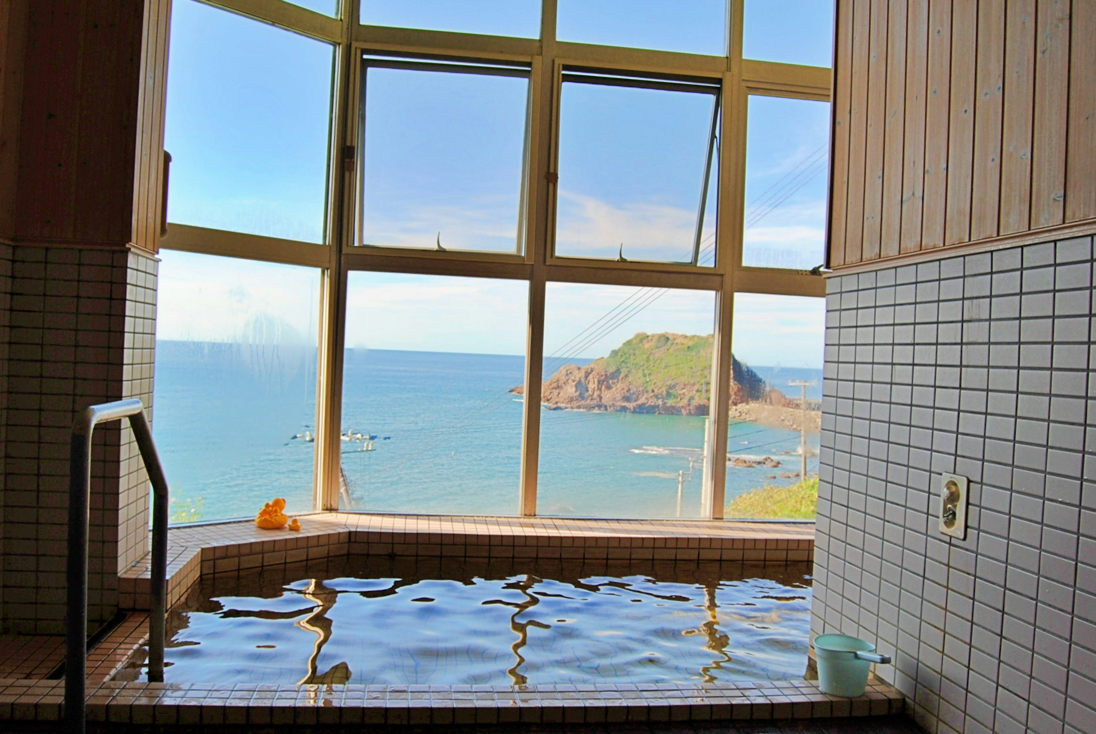 Indoor hot spring with a view of the sea natural light streaming through the windows