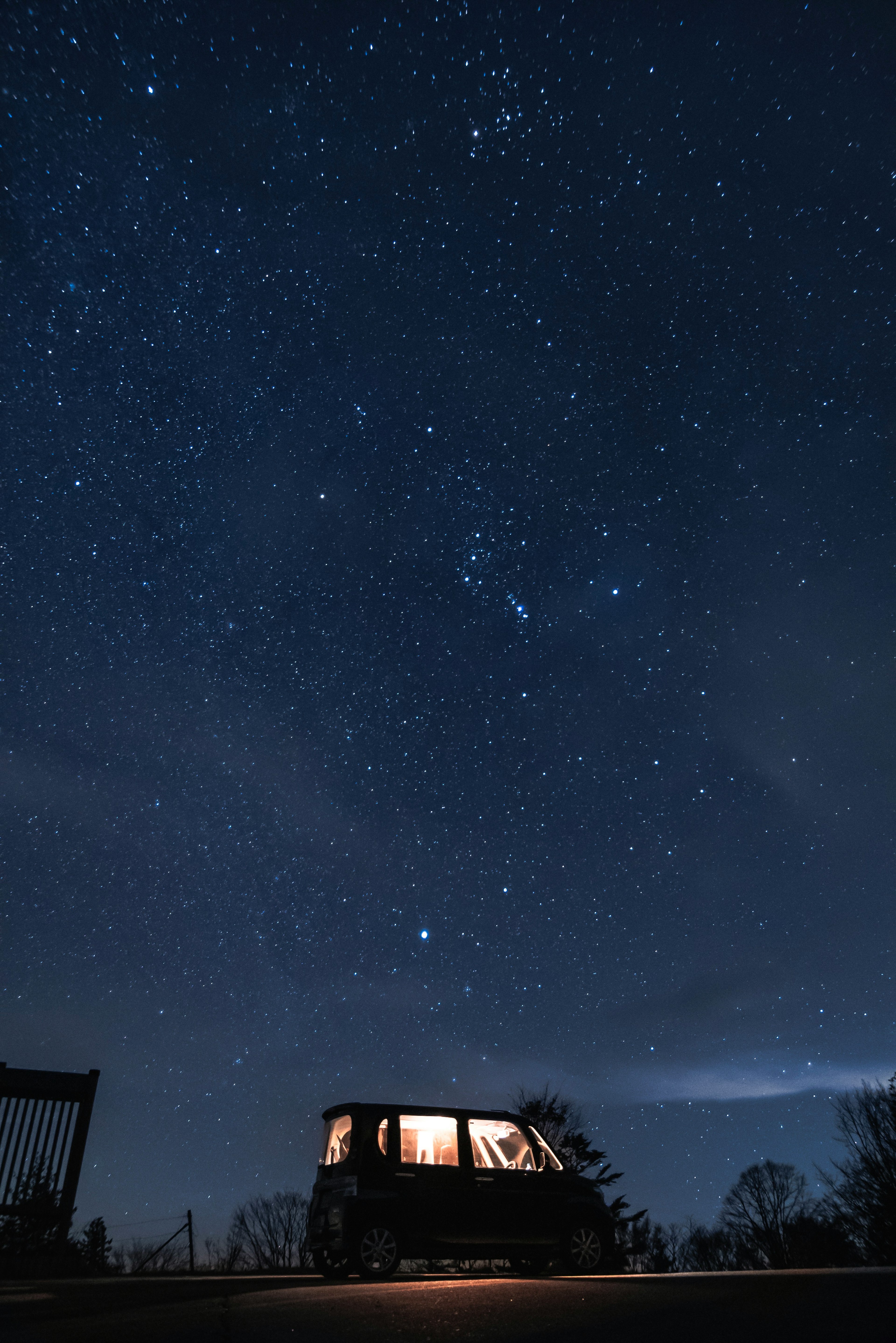 Auto unter einem sternenklaren Himmel mit zahlreichen Sternen