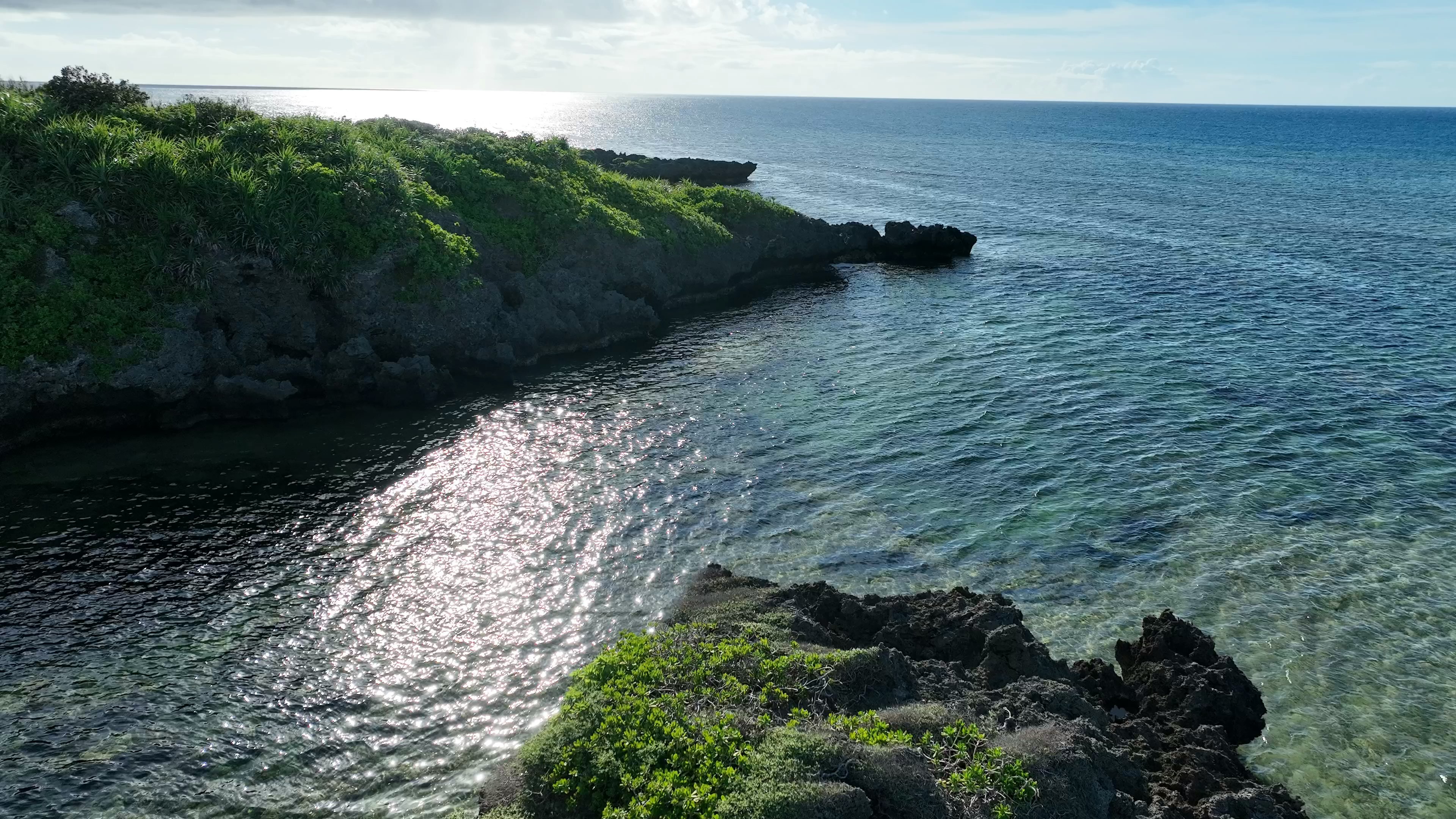 Pemandangan laut biru dan tebing hijau