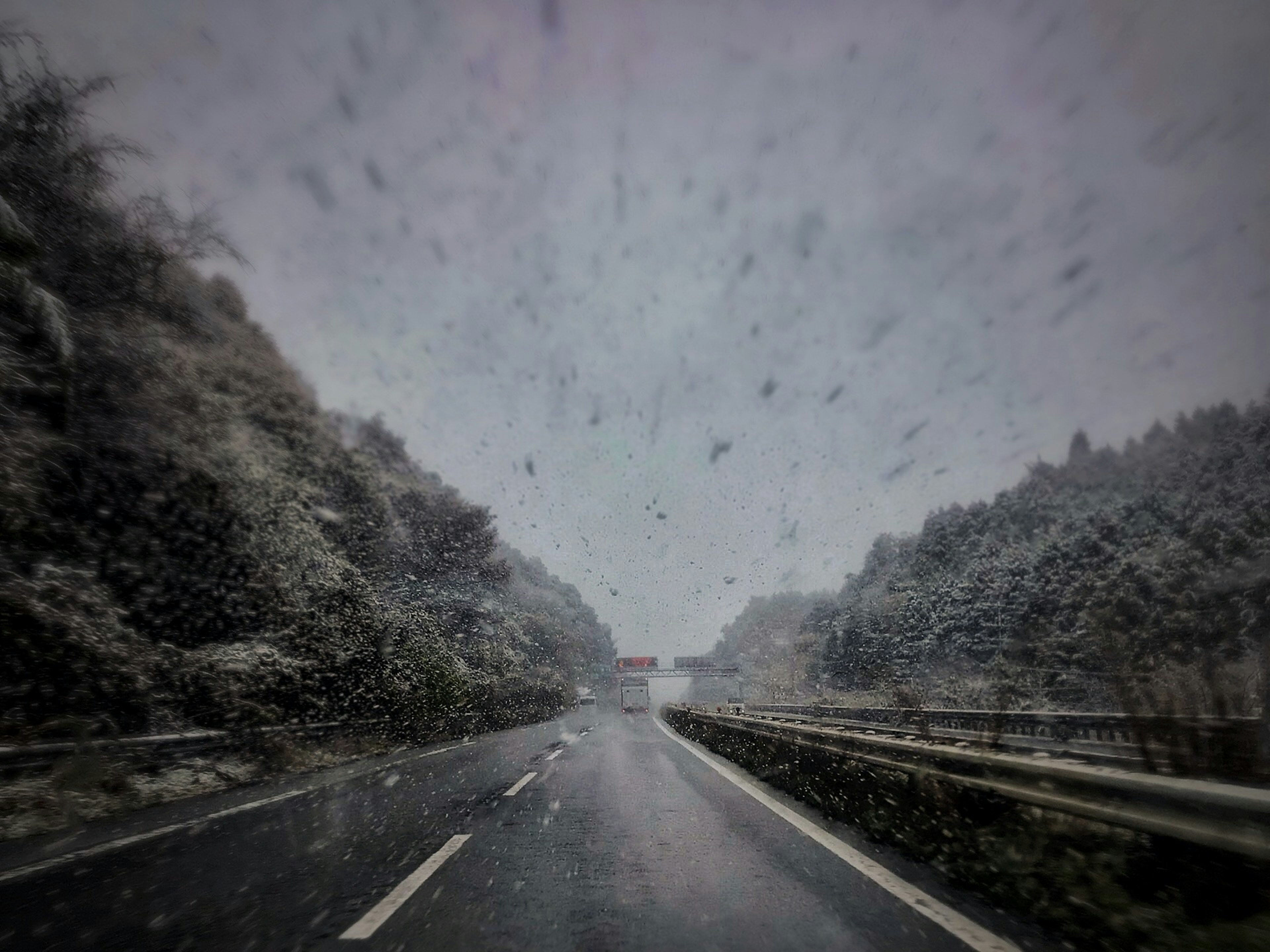 Scena di autostrada coperta di neve con neve che cade