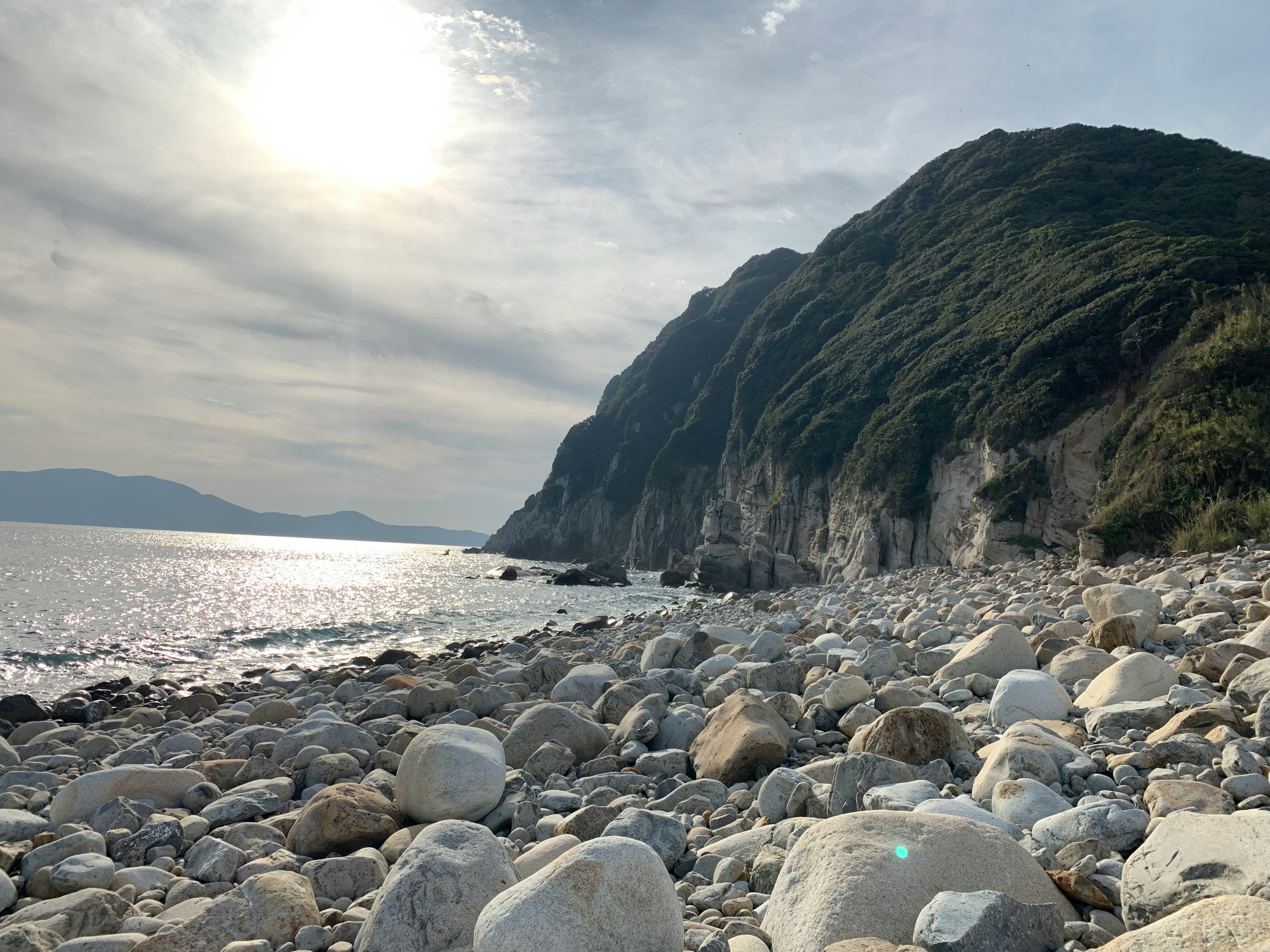 海岸の岩だらけの浜辺と高い山が見える風景