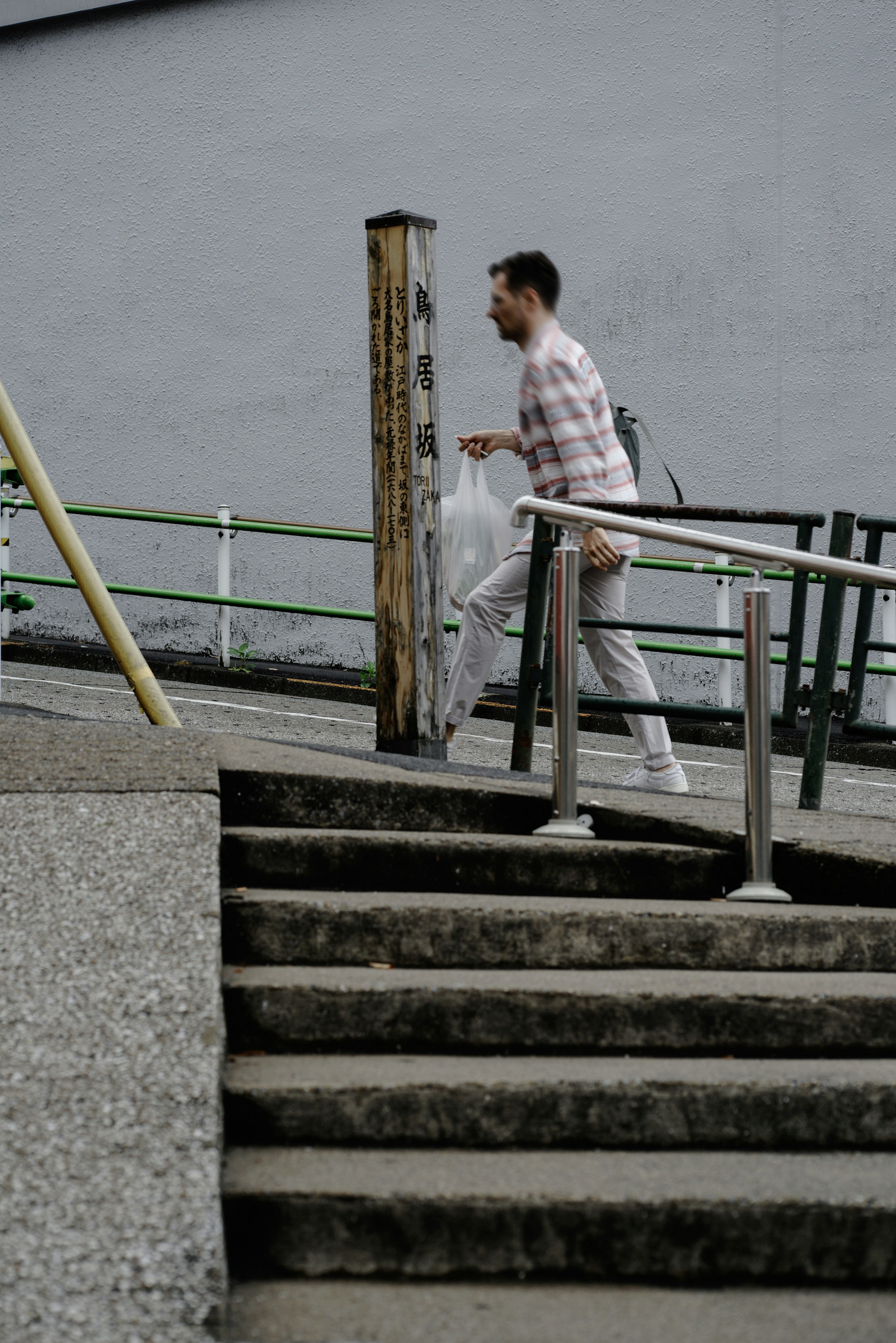 Ein Mann, der Treppen hinaufgeht und eine weiße Tasche trägt