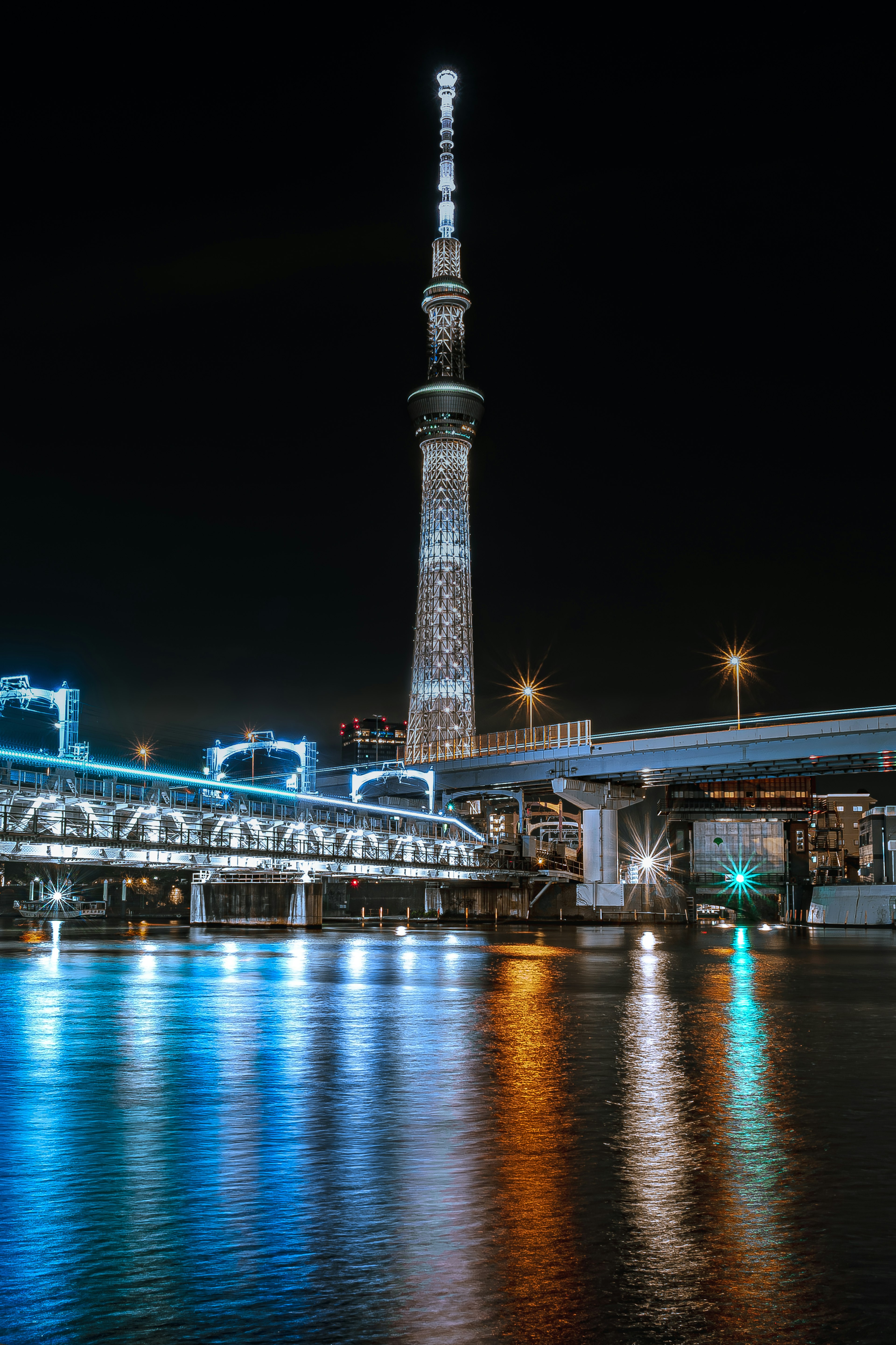 Tokyo Skytree iluminado de noche con reflejos en el agua