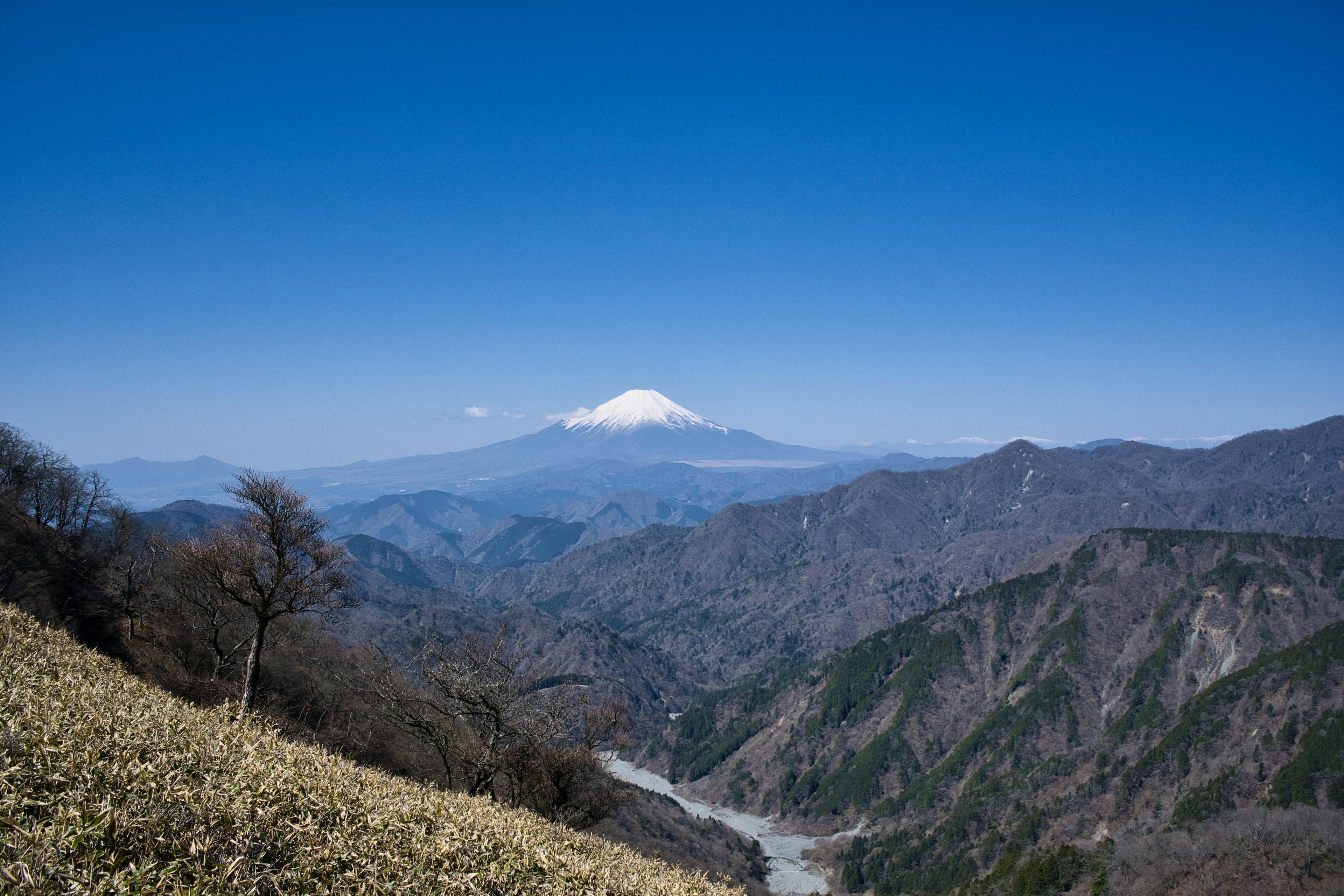 Snow-capped mountain under a blue sky with green valley