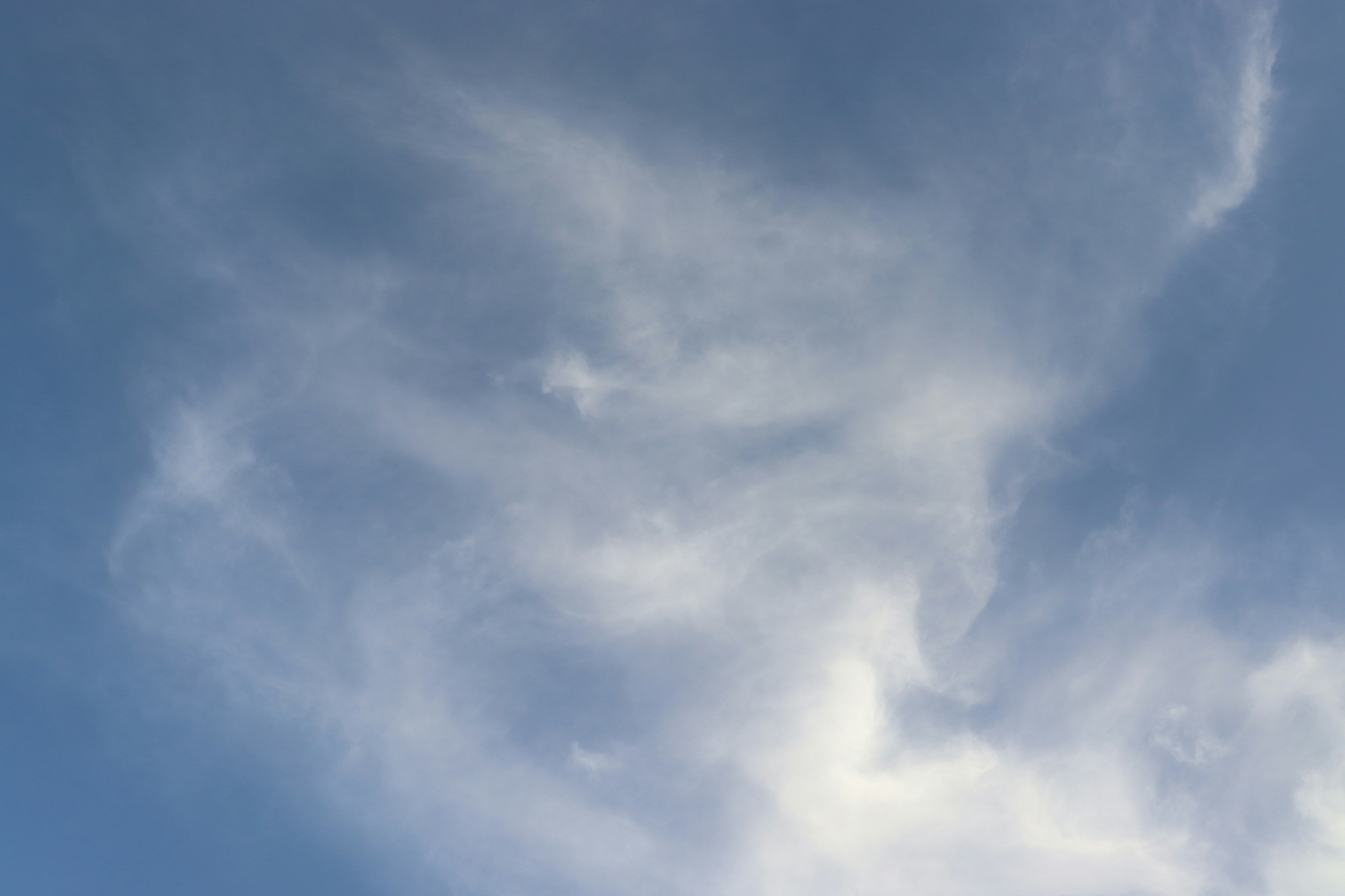 Verspielte Wolkenmuster in einem hellblauen Himmel