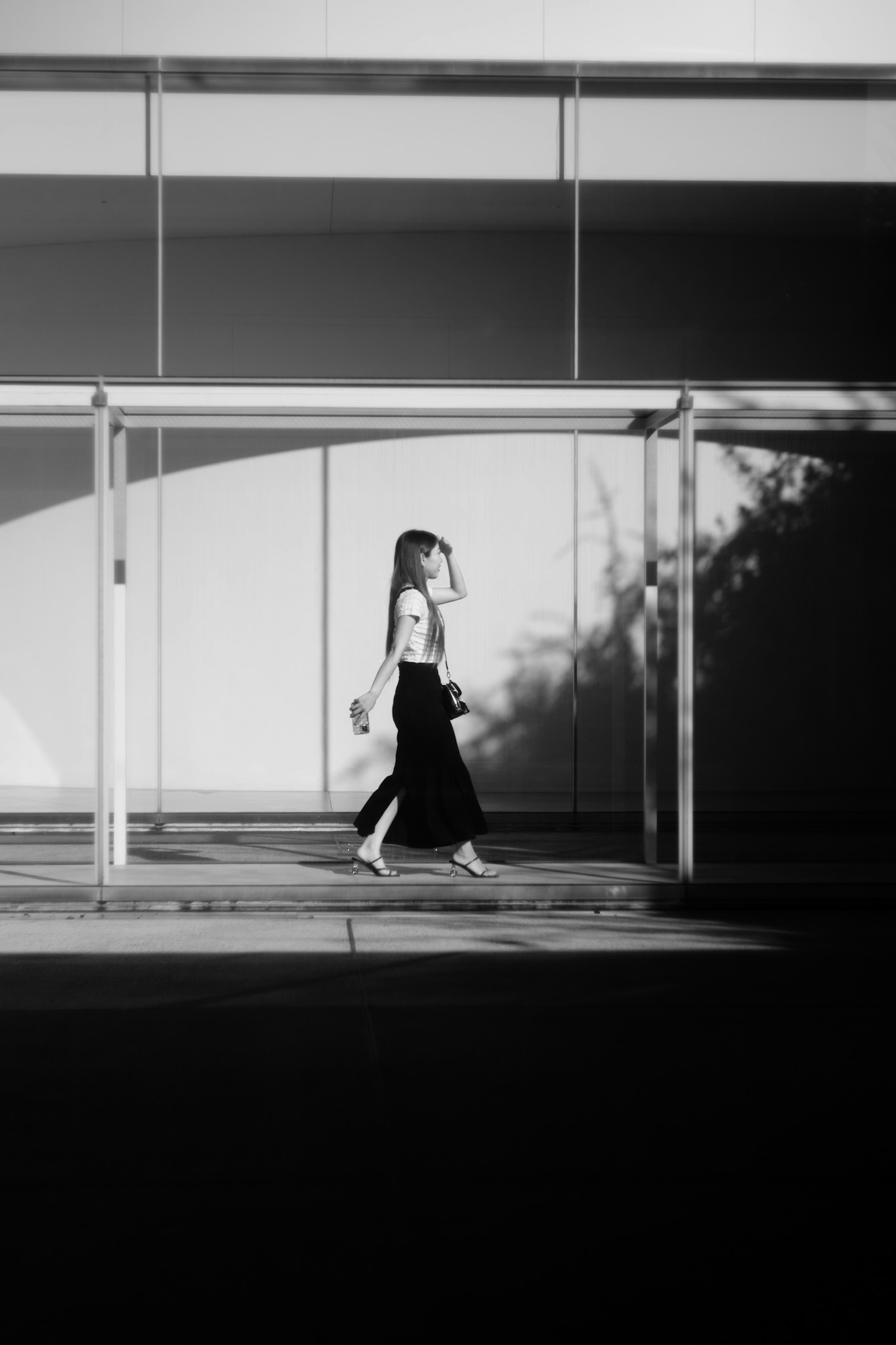 Silhouette of a woman walking against a black and white background