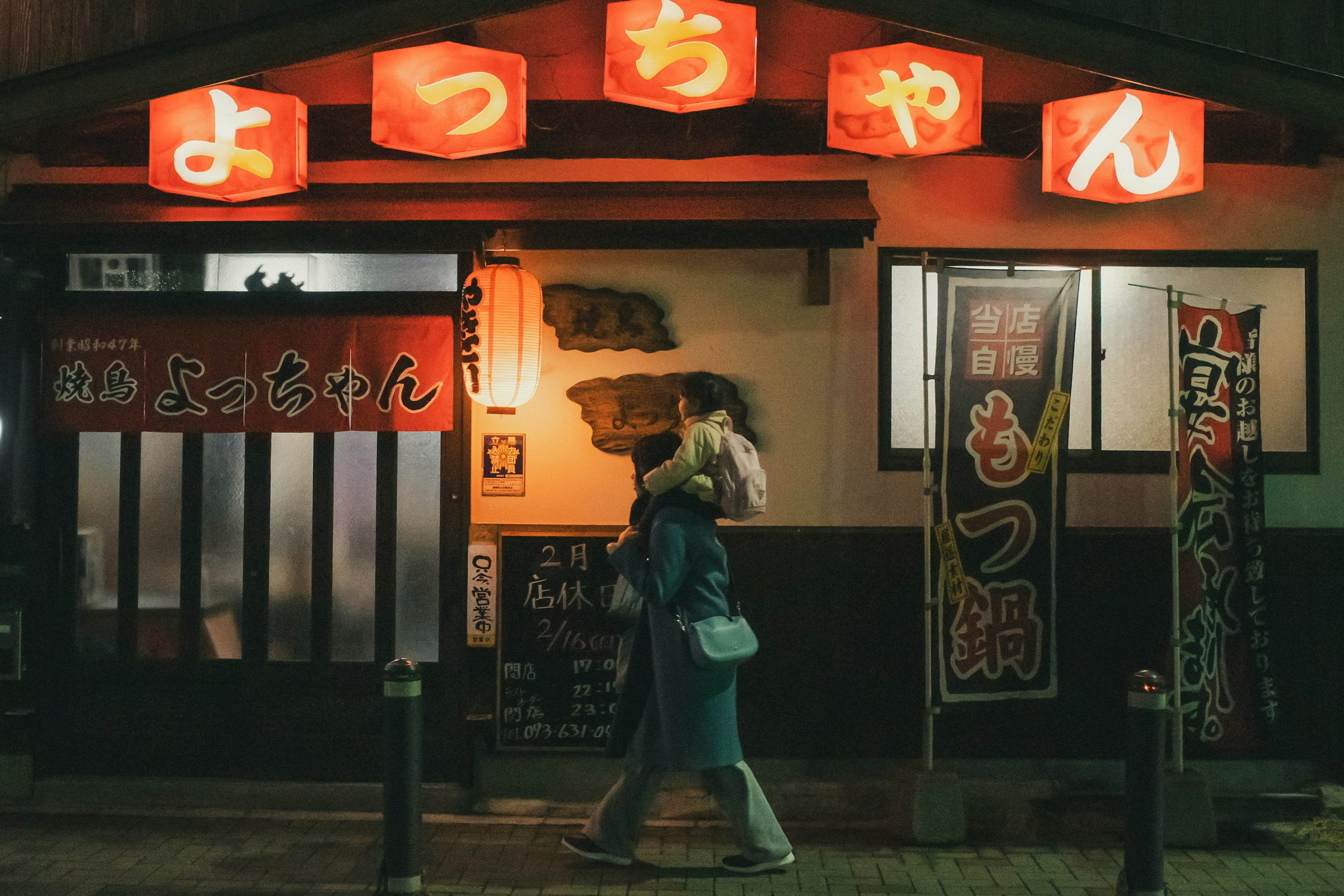 Exterior de un restaurante japonés por la noche con llamativas linternas rojas