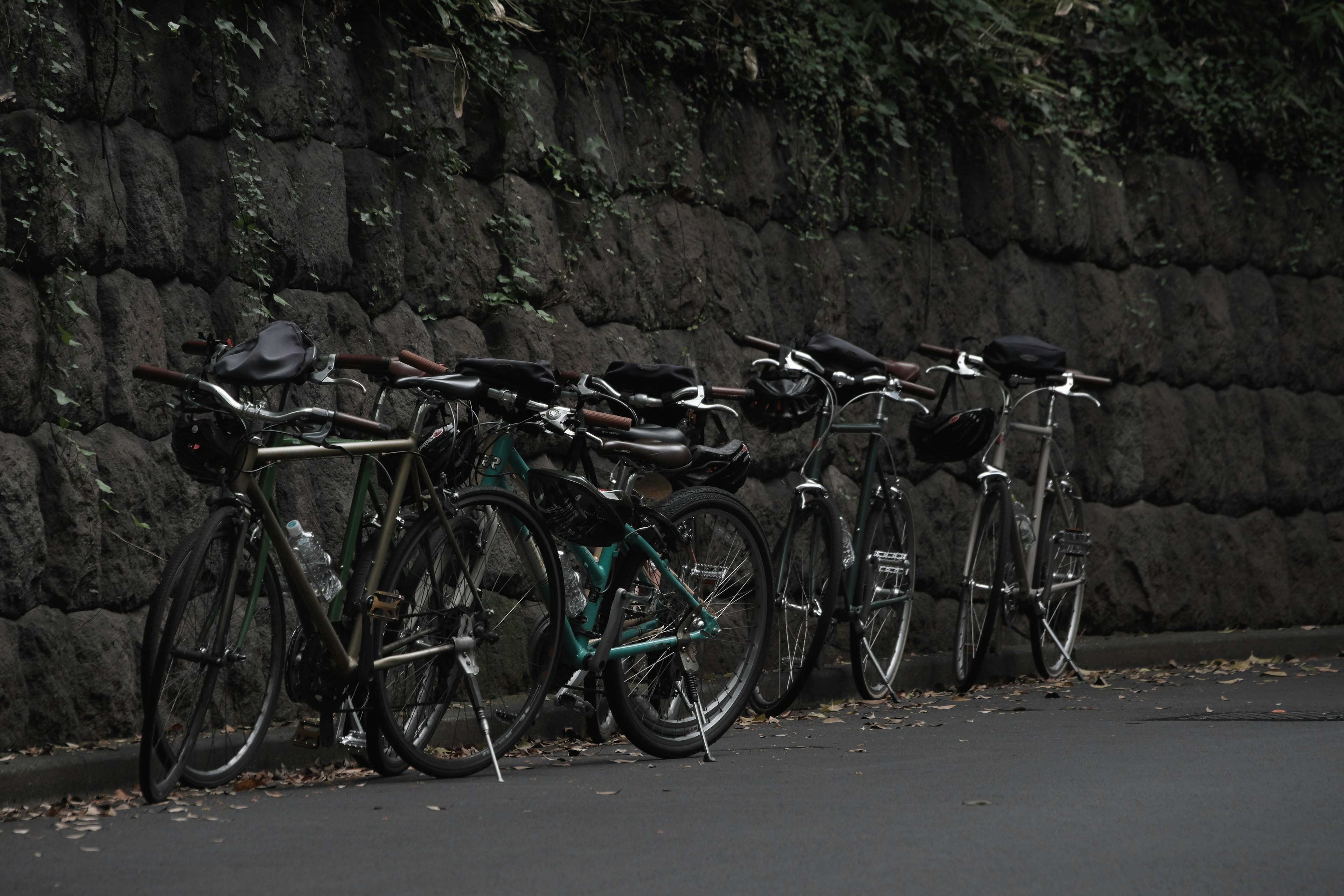 Bicicletas apoyadas contra una pared de piedra