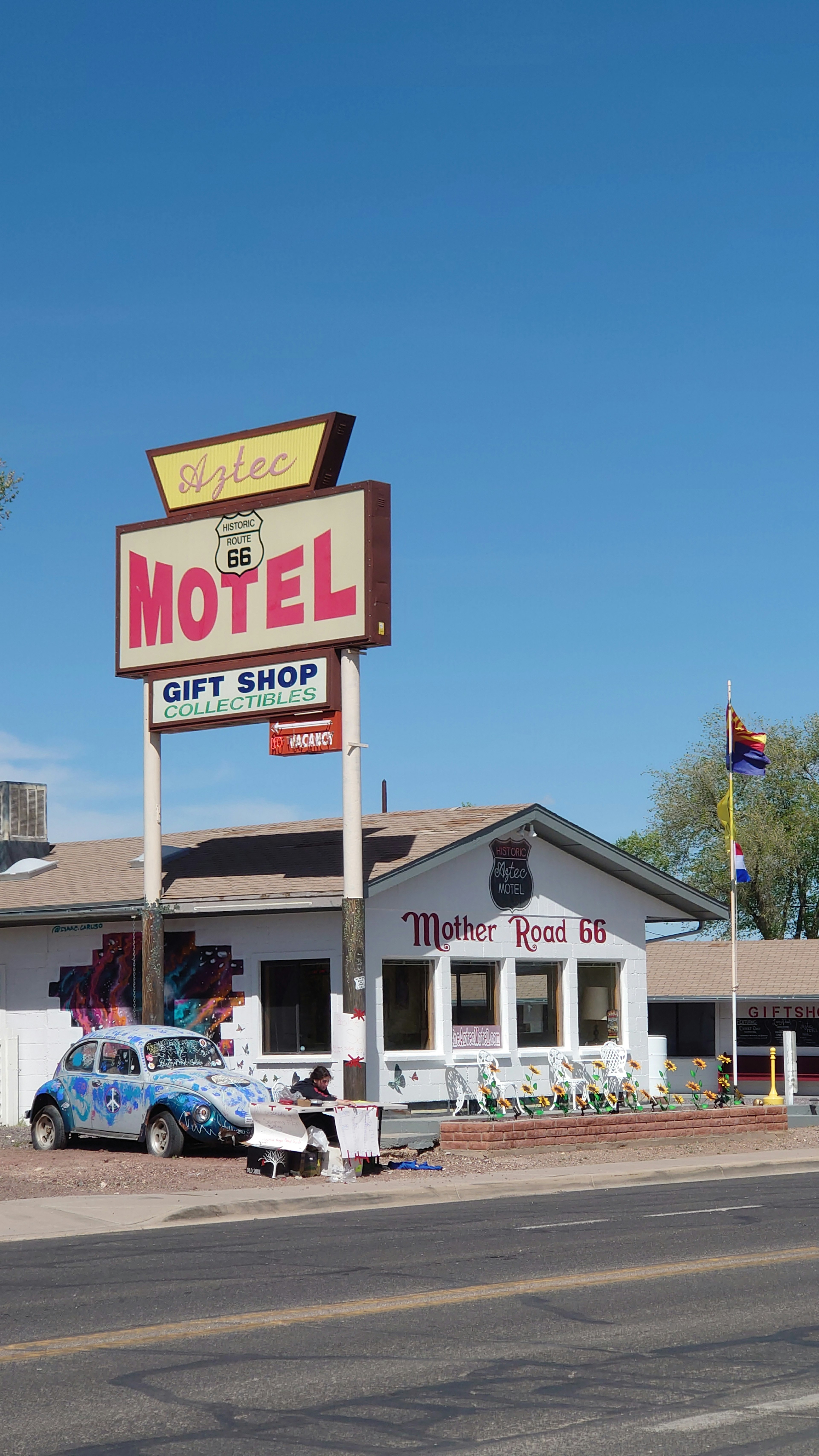 Motel sign and gift shop exterior in a sunny setting