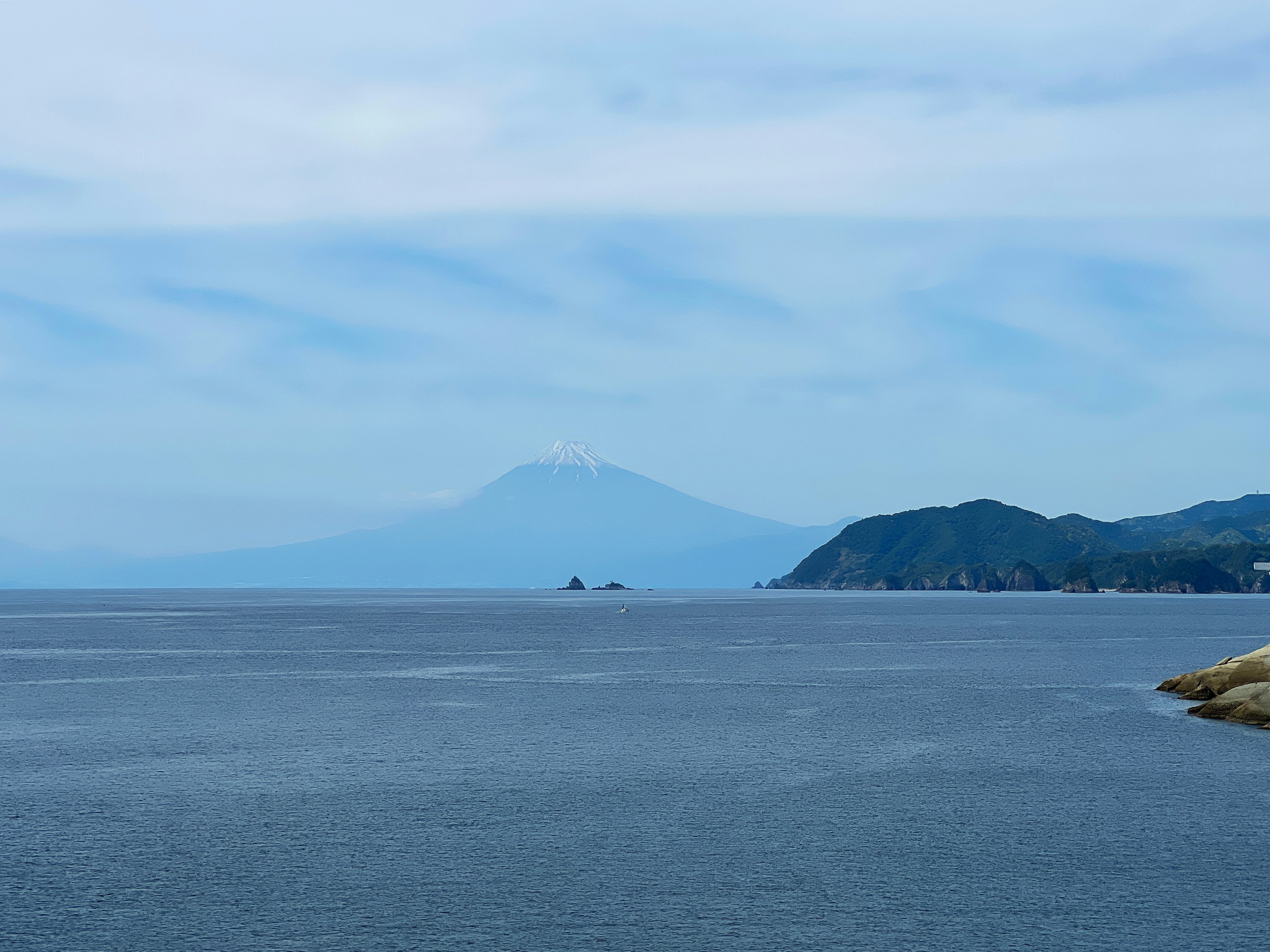 Pemandangan indah Gunung Fuji di latar belakang dengan laut biru dan awan