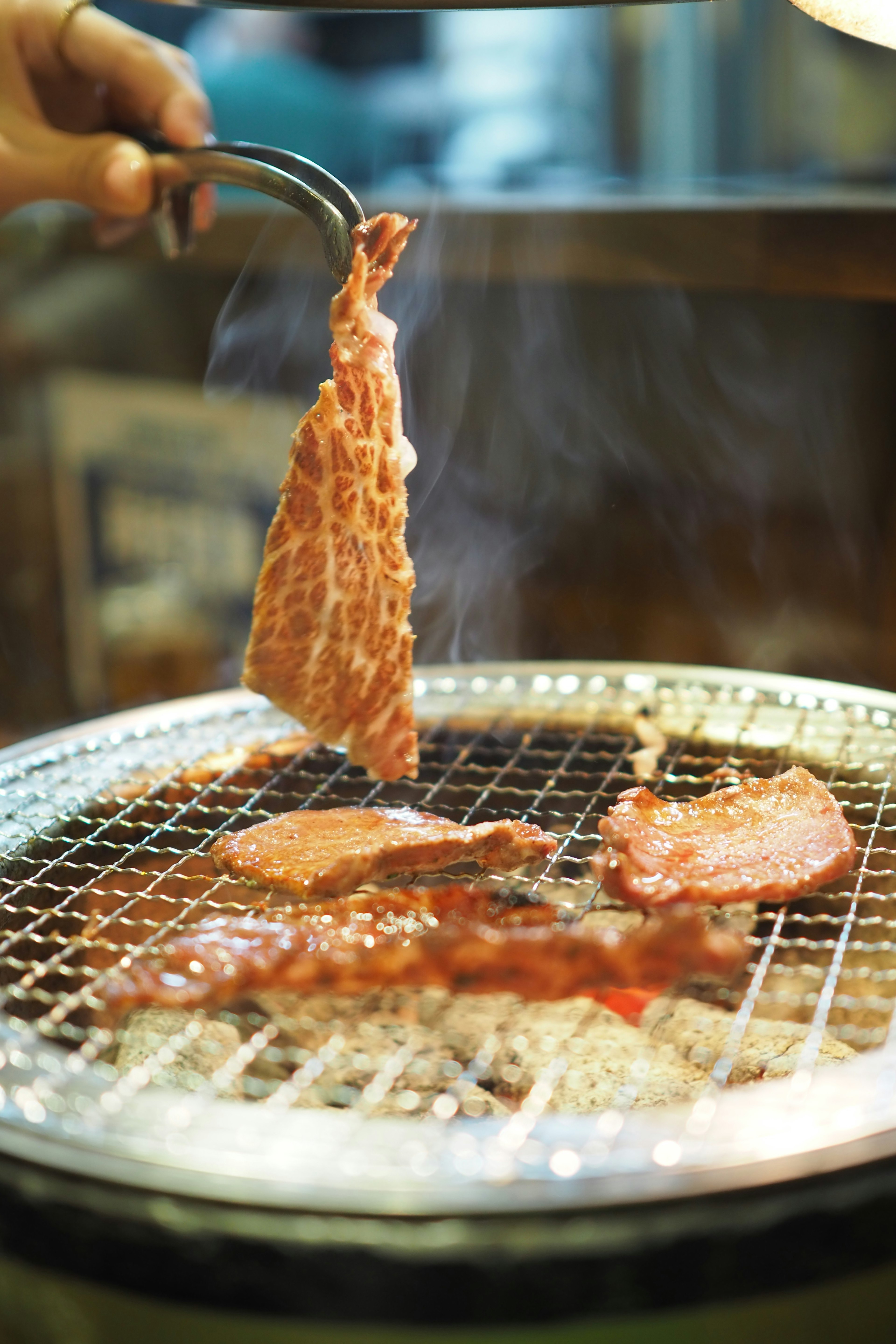 焼かれている肉とグリルの煙