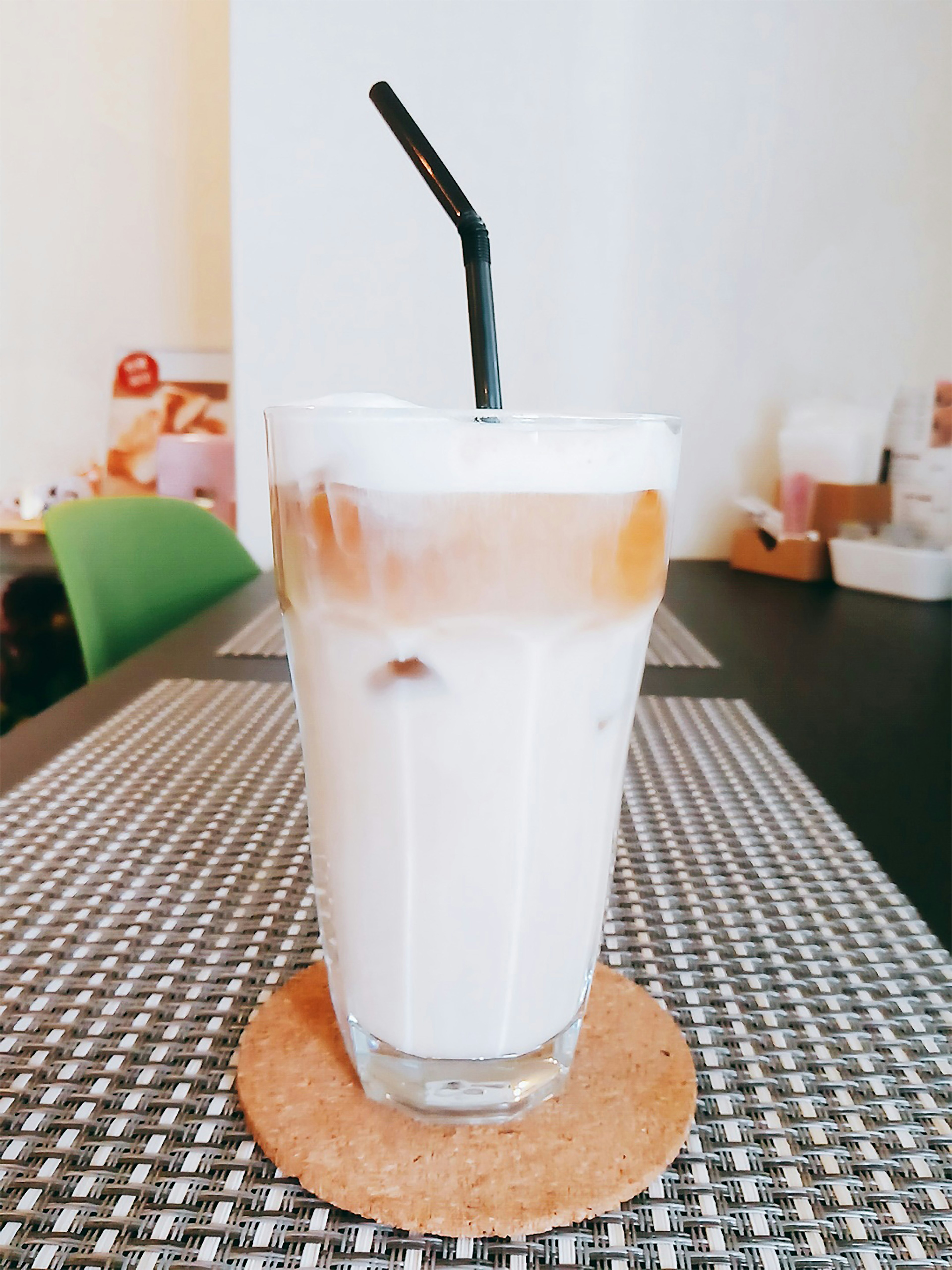 A clear glass filled with iced coffee and milk on a table